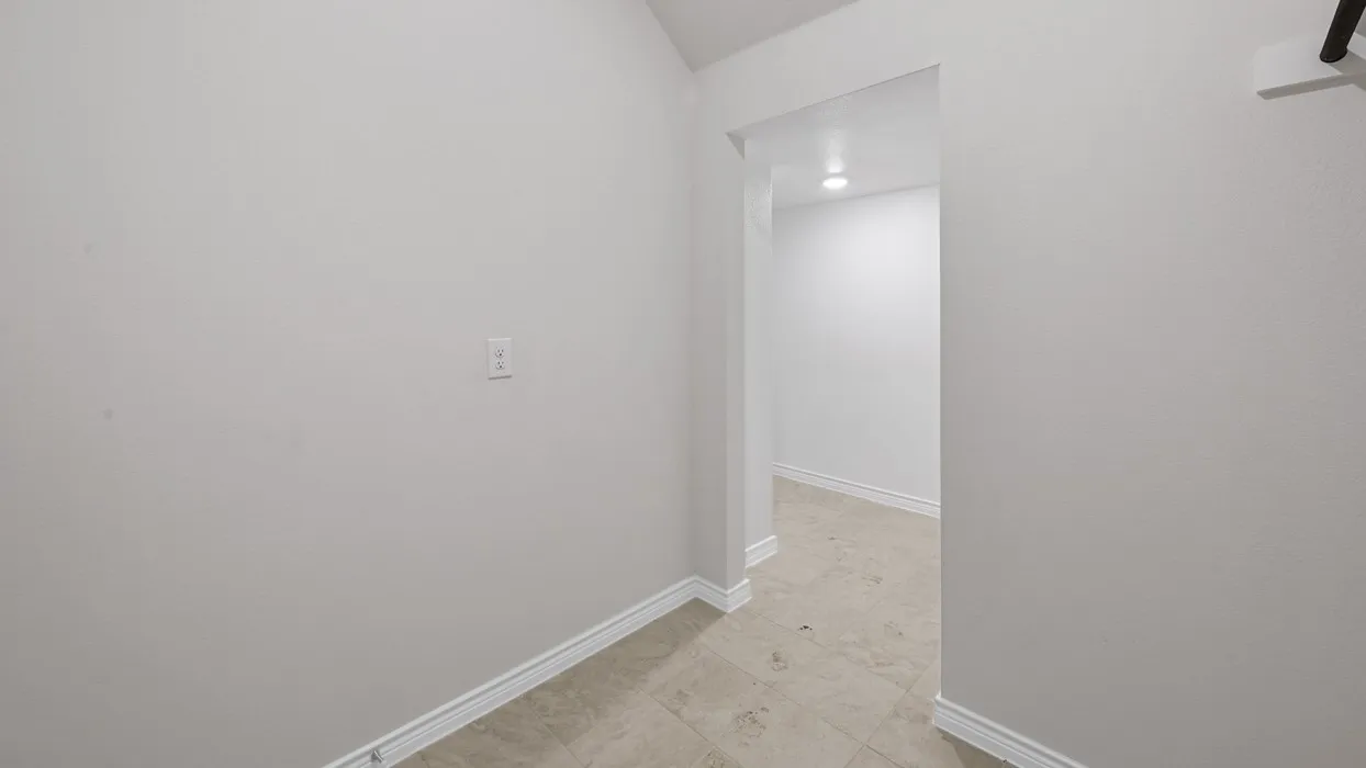 Interior hallway with light-toned wall paint and matching baseboards