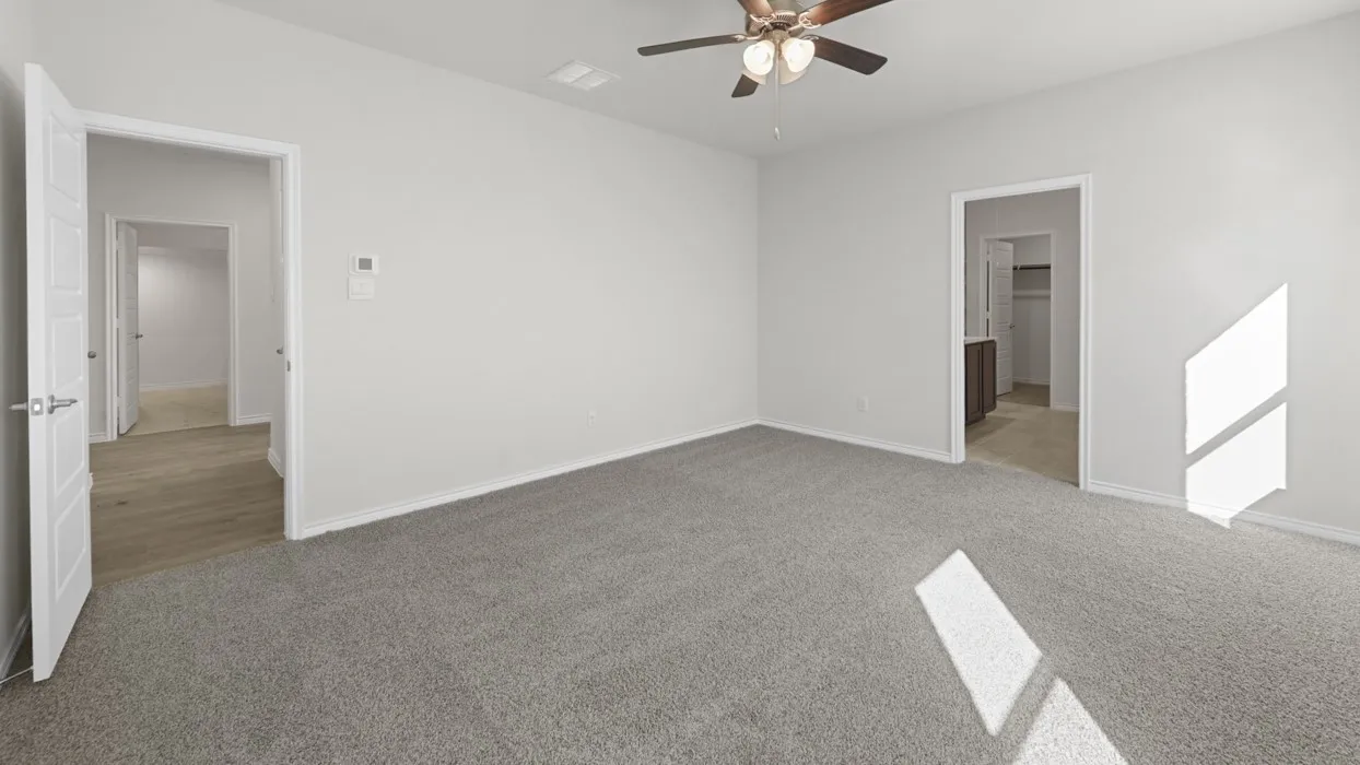 Spacious interior room featuring light gray carpet flooring and white painted walls