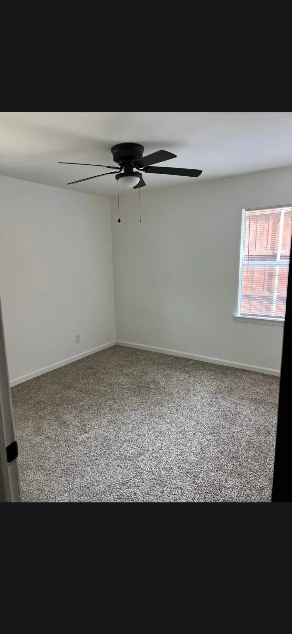 Bedroom featuring fresh neutral paint, grey carpet, and a ceiling fan with integrated lighting