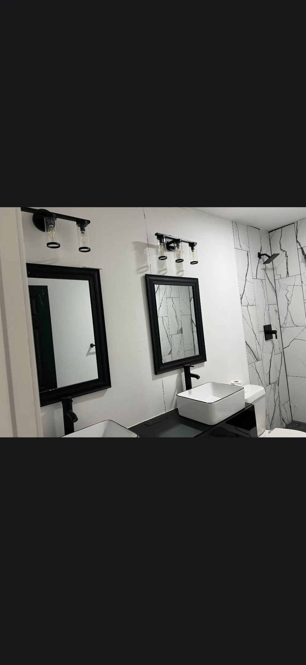 Bathroom featuring a dual vanity with rectangular vessel sinks, wall-mounted matte black faucets, and coordinating framed mirrors