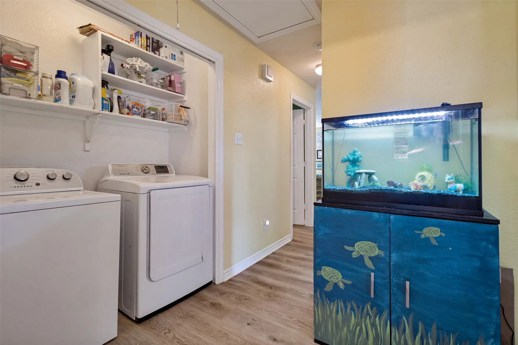 The laundry area is conveniently located at the end of the hall and has built-in shelving.