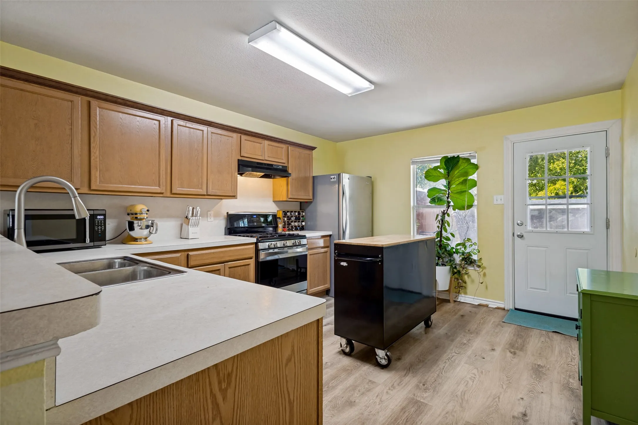 The kitchen maximizes storage and workspace with ample room for your choice of a small dinette set or portable island.
