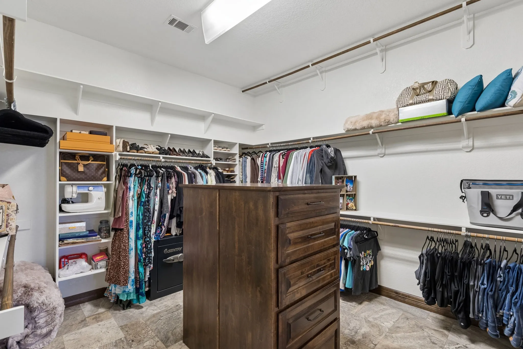 Oversized primary suite closet with triple hanging rods and built in dressers. There is also an additional closet in the primary suite if the couple would like to have separate closets.