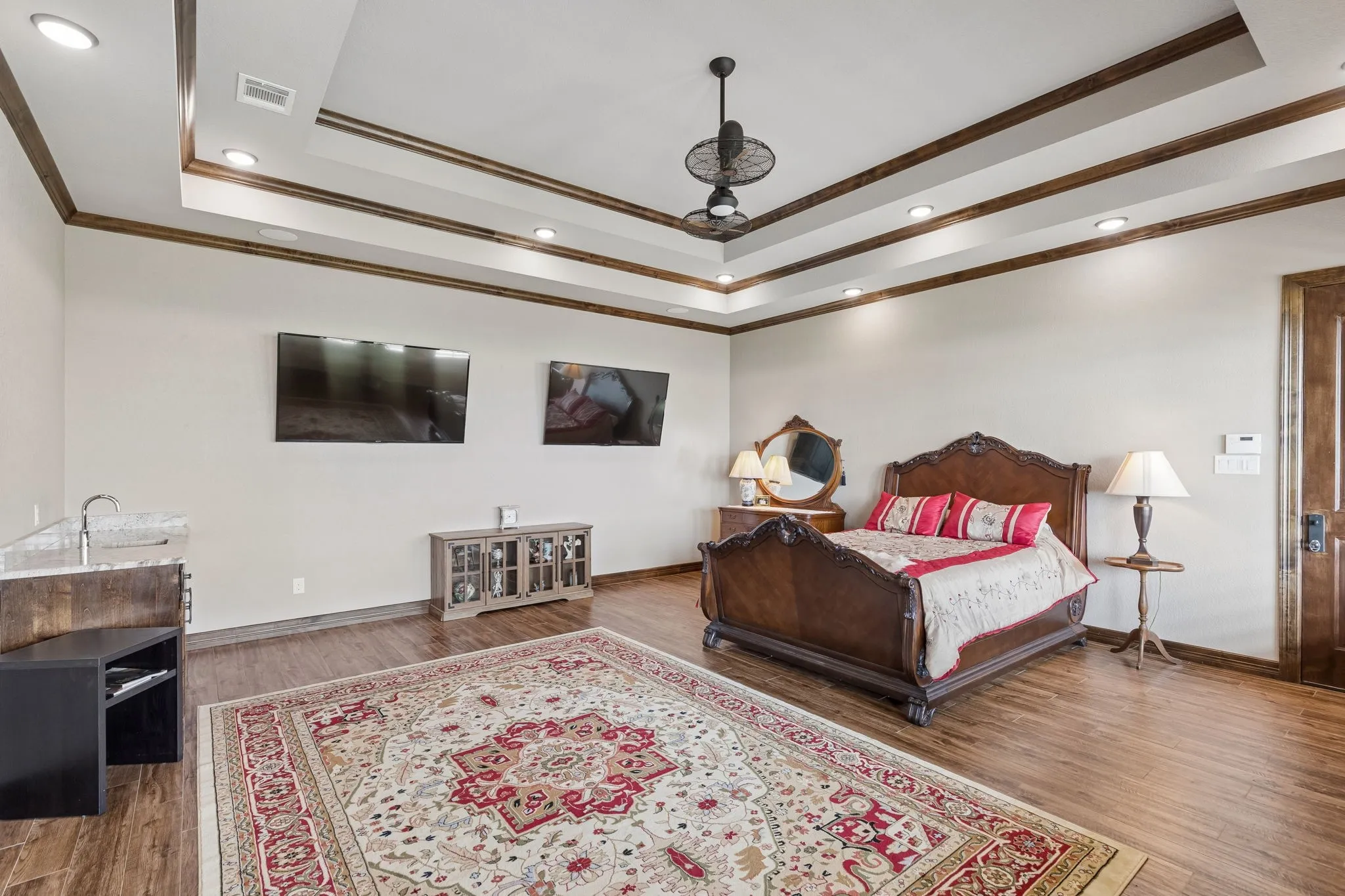 Game room with tray ceiling, private door to front porch, wet bar and the television is included.