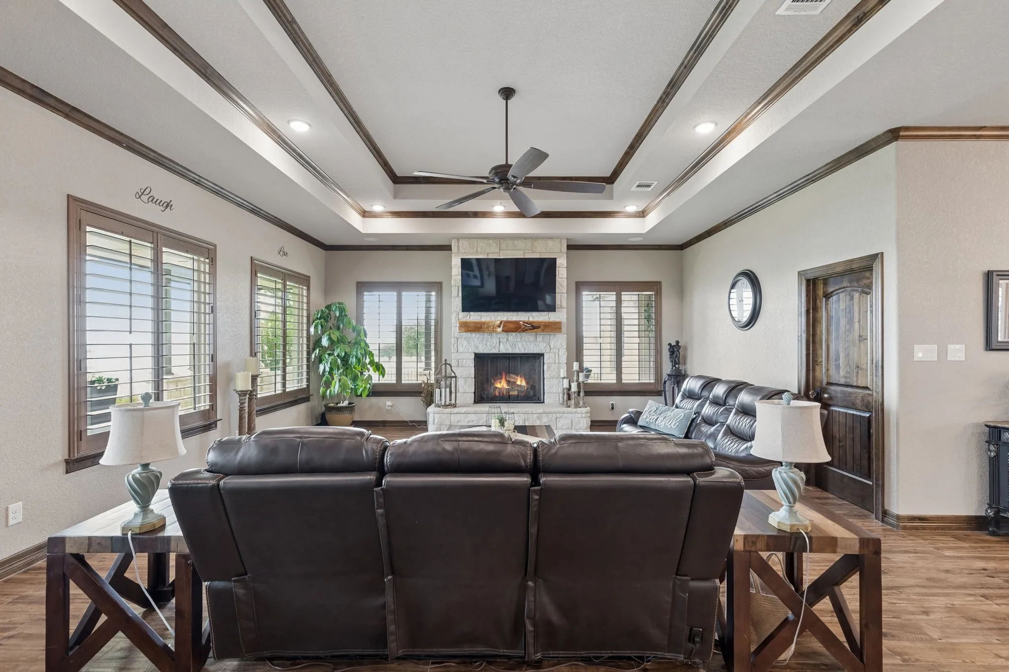 A stone full facade fireplace with hearth and custom natural wood ledge give this room an elegant lodge-type feel. The multi-use media closet is on the right in this picture.
