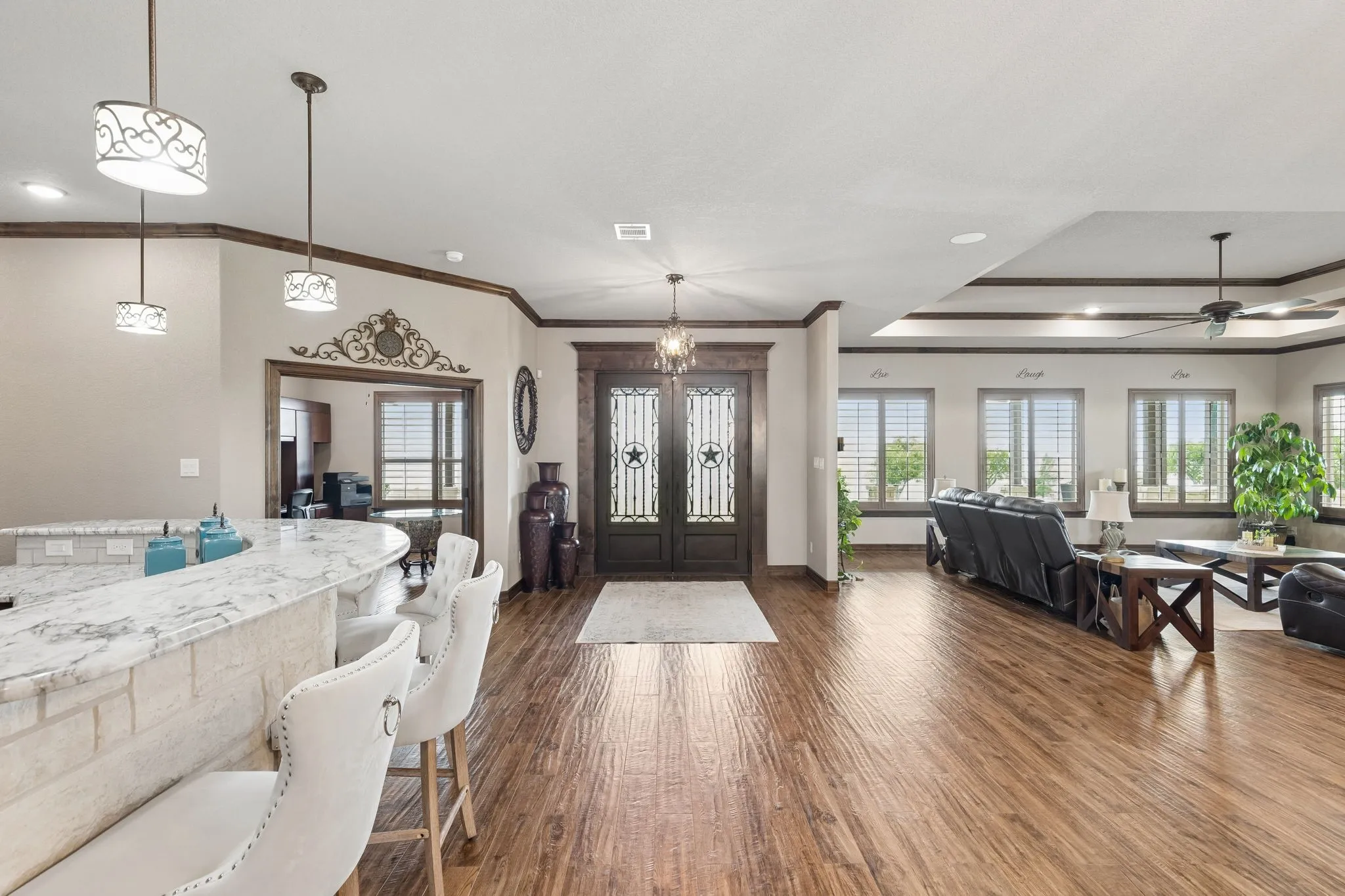 Beautiful granite breakfast bar for entertaining and convenience. Office pictured here on the left, gorgeous double iron front doors and abundant windows for natural light and view of the sunset.