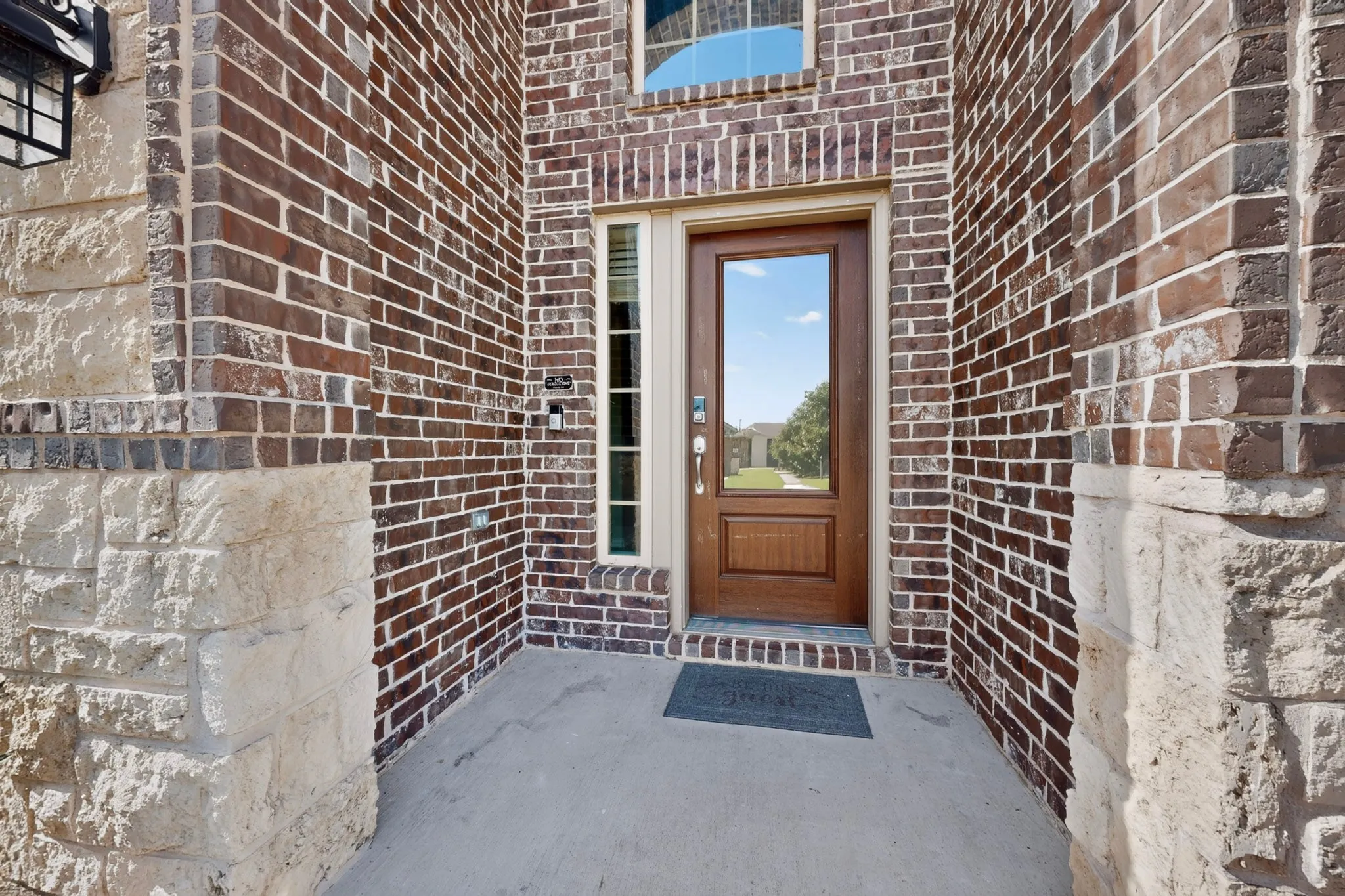 Entryway featuring a wood-panel door with a full-light glass insert, sidelight window, and transom window