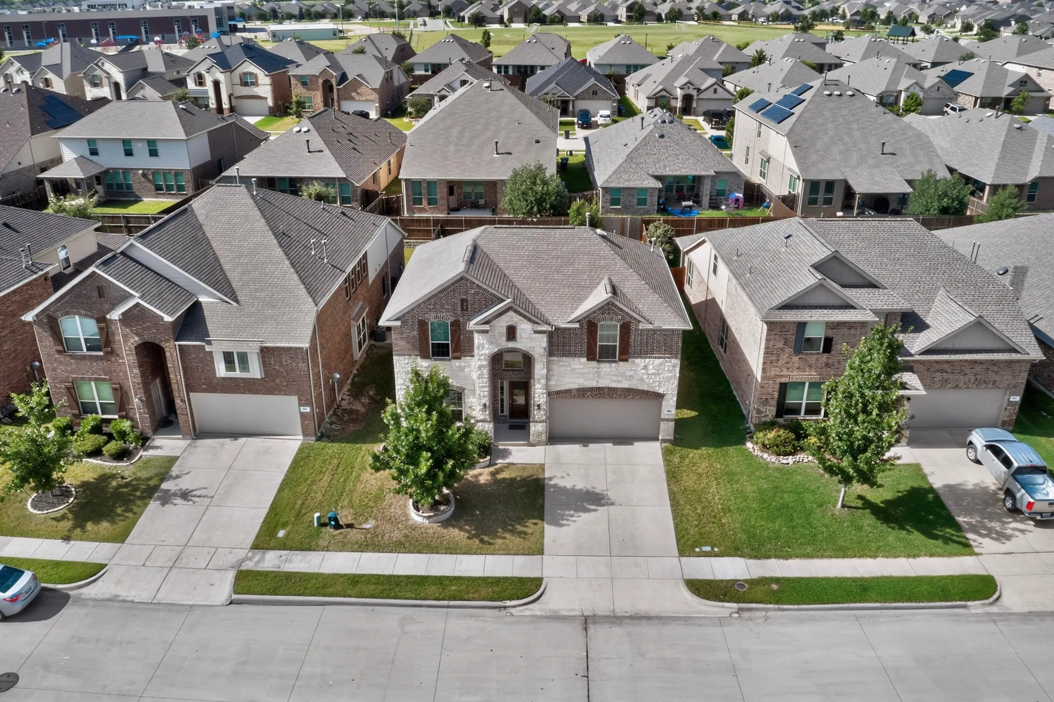 Two-story residential property featuring a brick and stone facade, an attached two-car garage, and a gabled roof