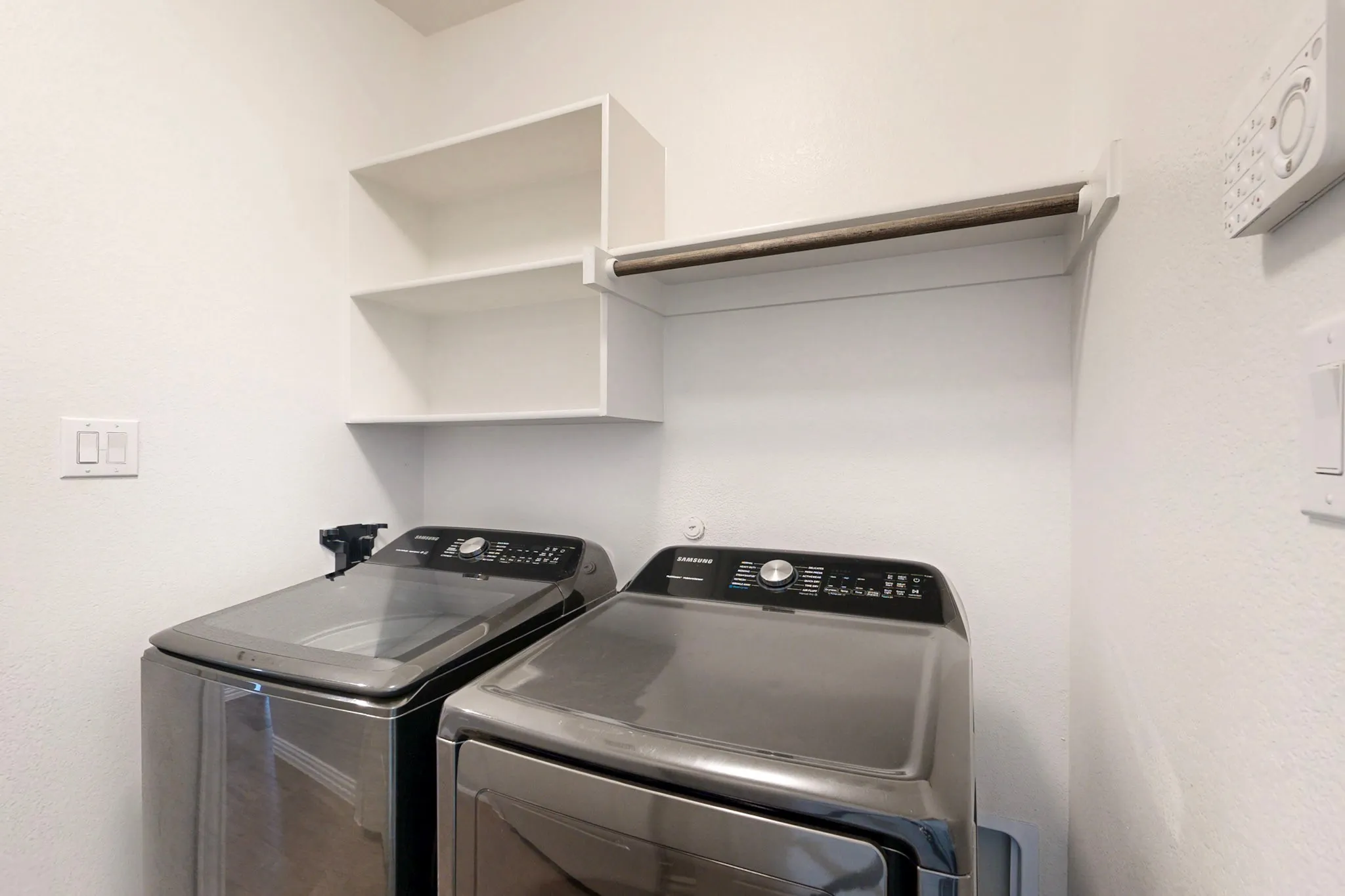Dedicated laundry area featuring white painted walls and built-in shelving