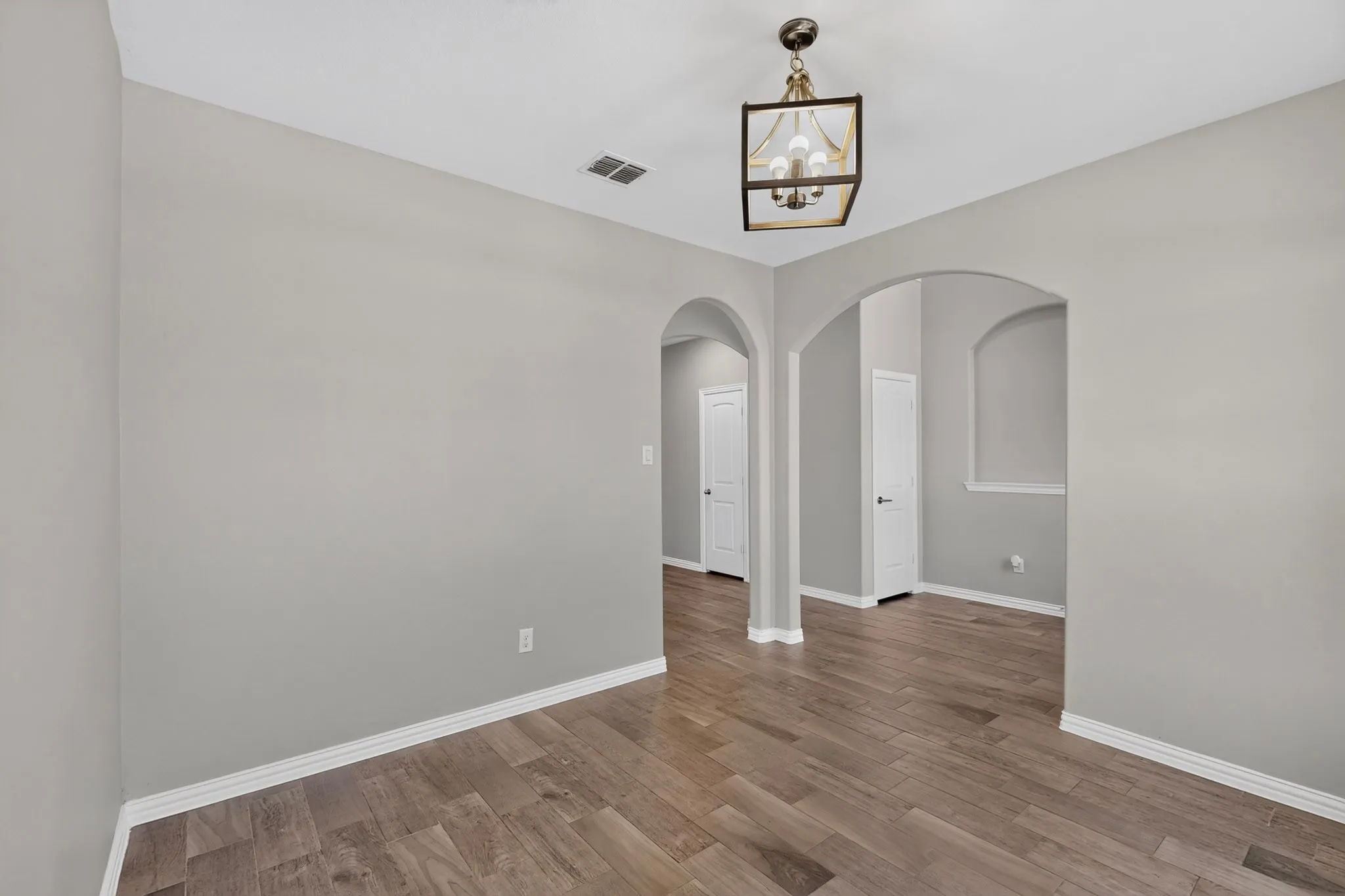 Interior space featuring wood-finish flooring, light gray wall tones, and white baseboards