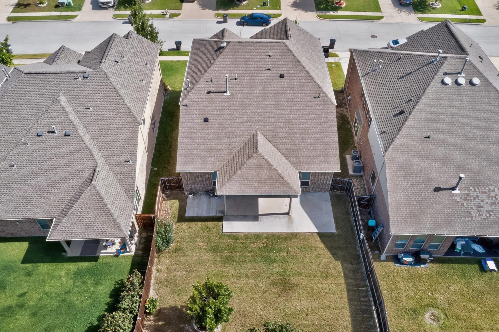 Expansive rear yard featuring a covered patio, concrete slab, and wood-fencing