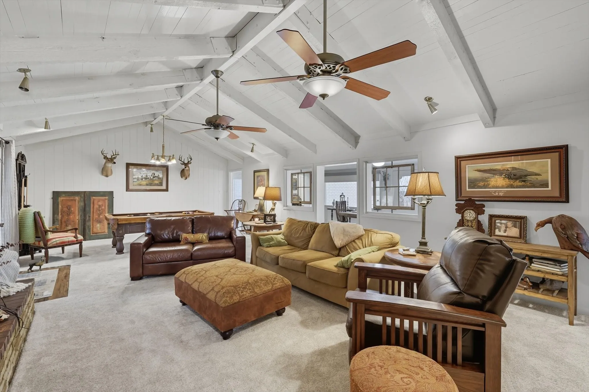 Living room with carpet flooring, a ceiling fan, and pool table