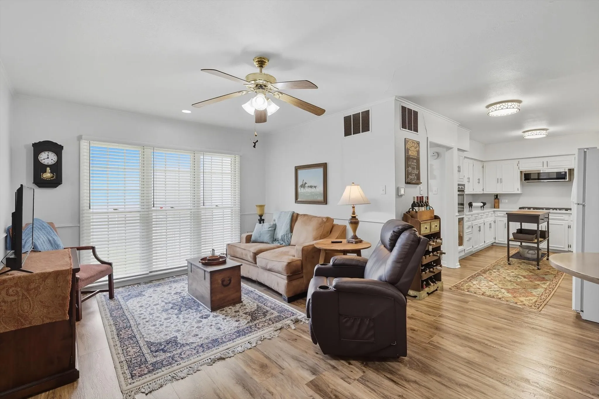 2nd living area with light wood-type flooring and a ceiling fan