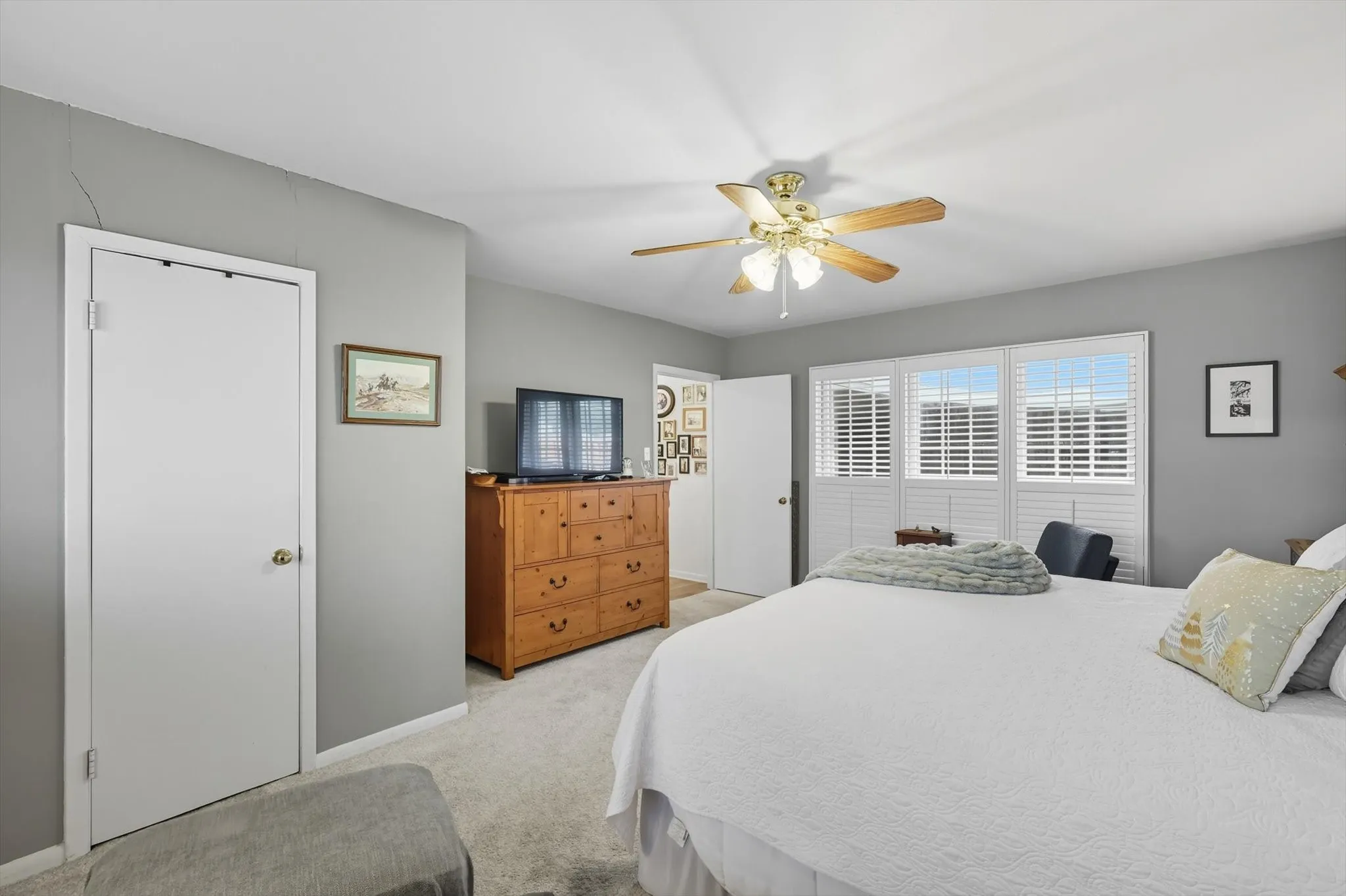 Bedroom with light colored carpet and a ceiling fan
