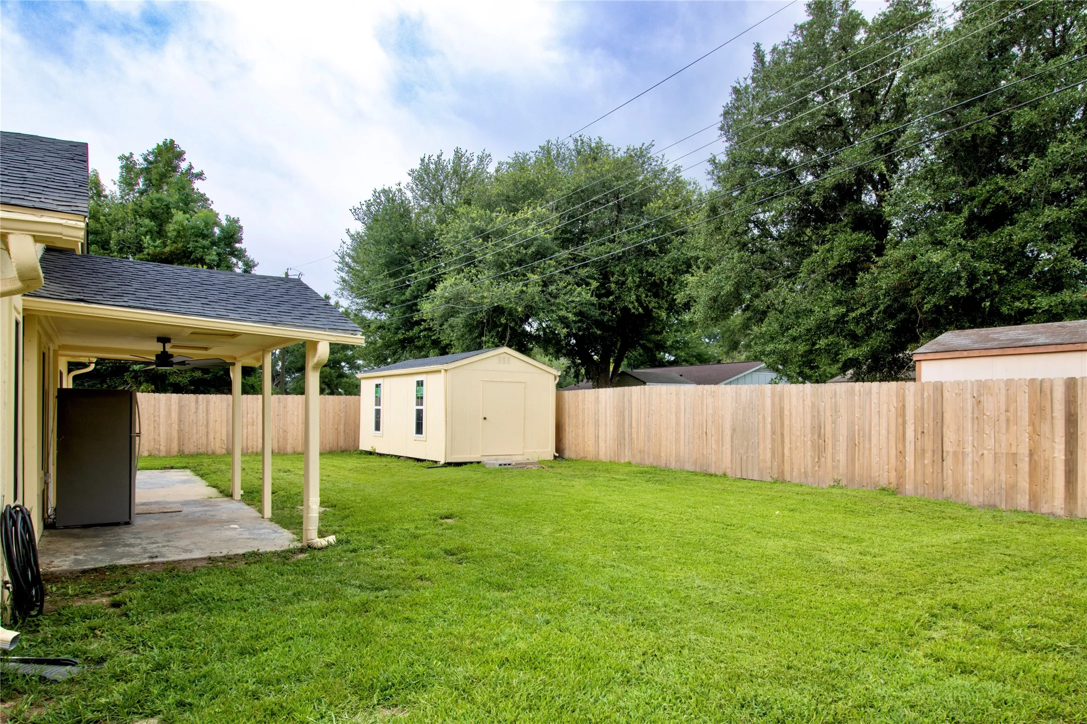 Expansive green lawn with a newly installed privacy fence