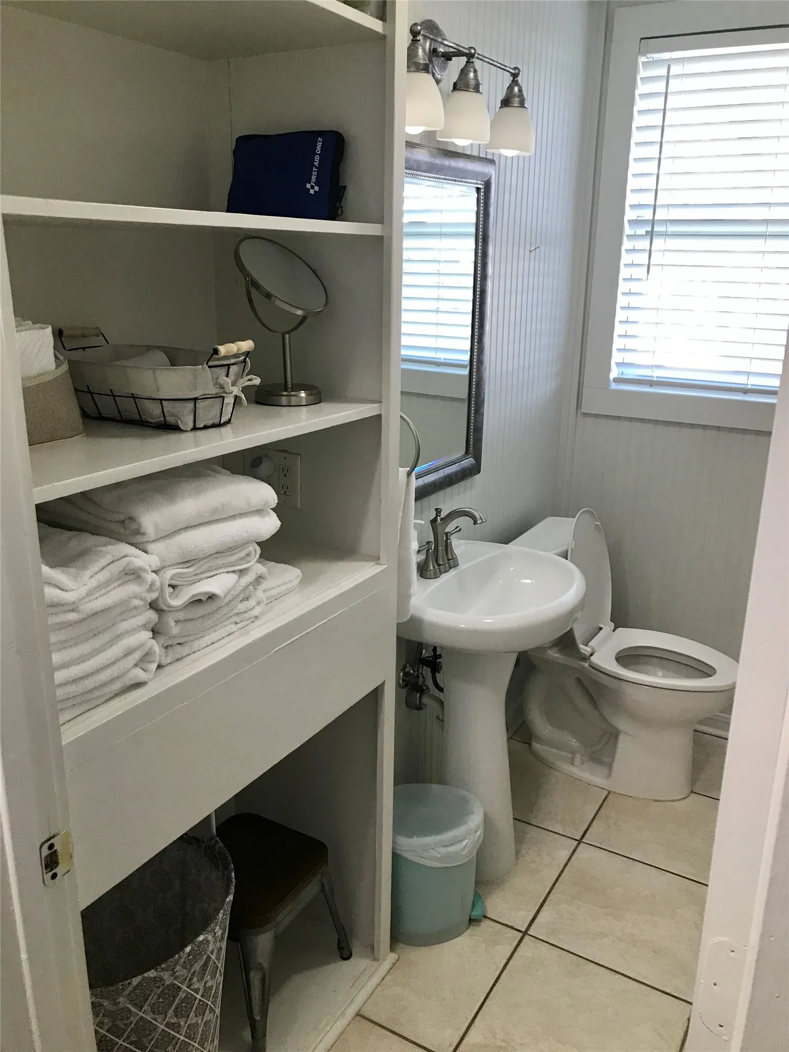 Bathroom featuring a pedestal sink, toilet, and built-in shelving
