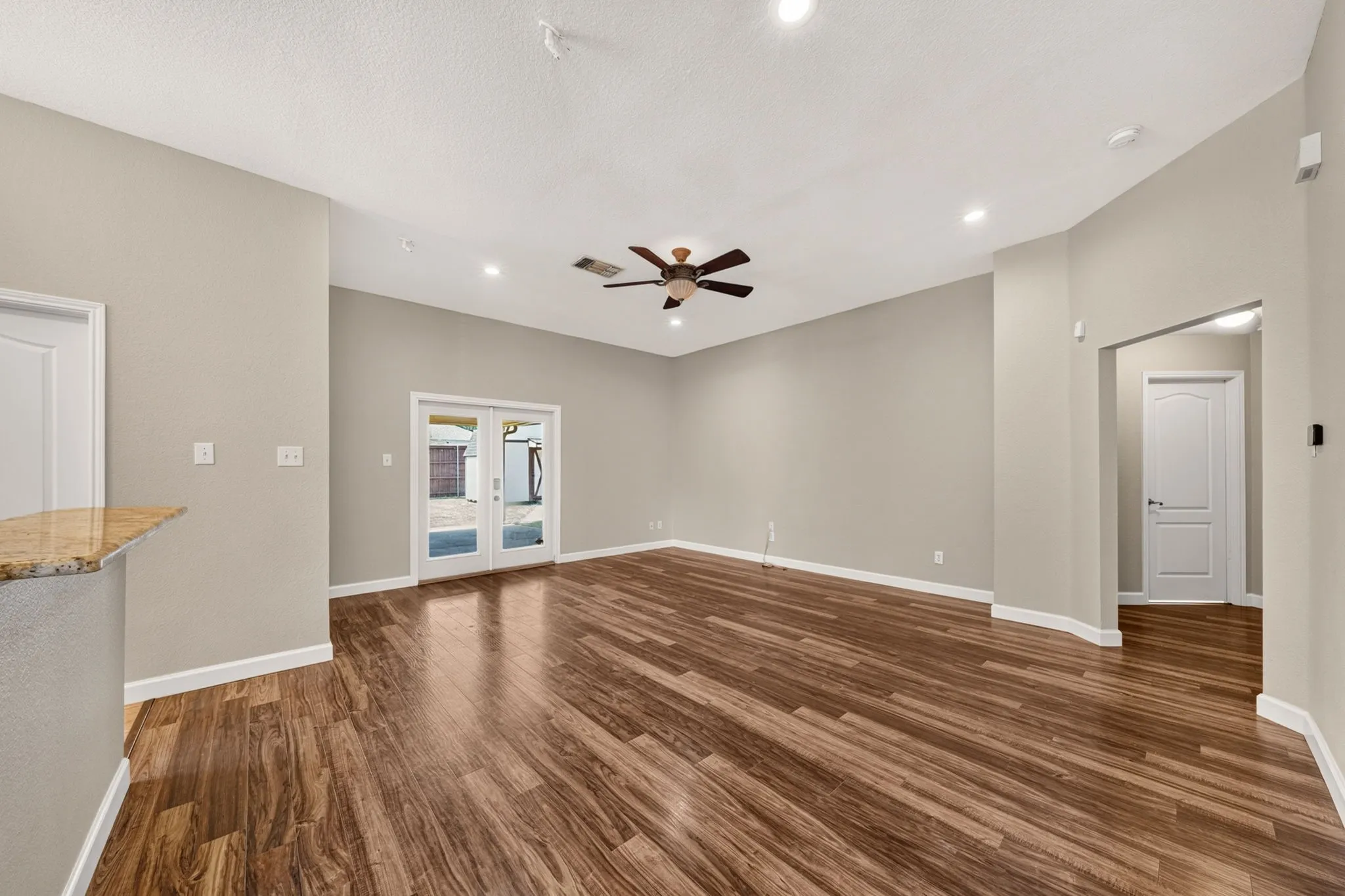 Tall ceilings complement the wood-finish flooring in this main living area