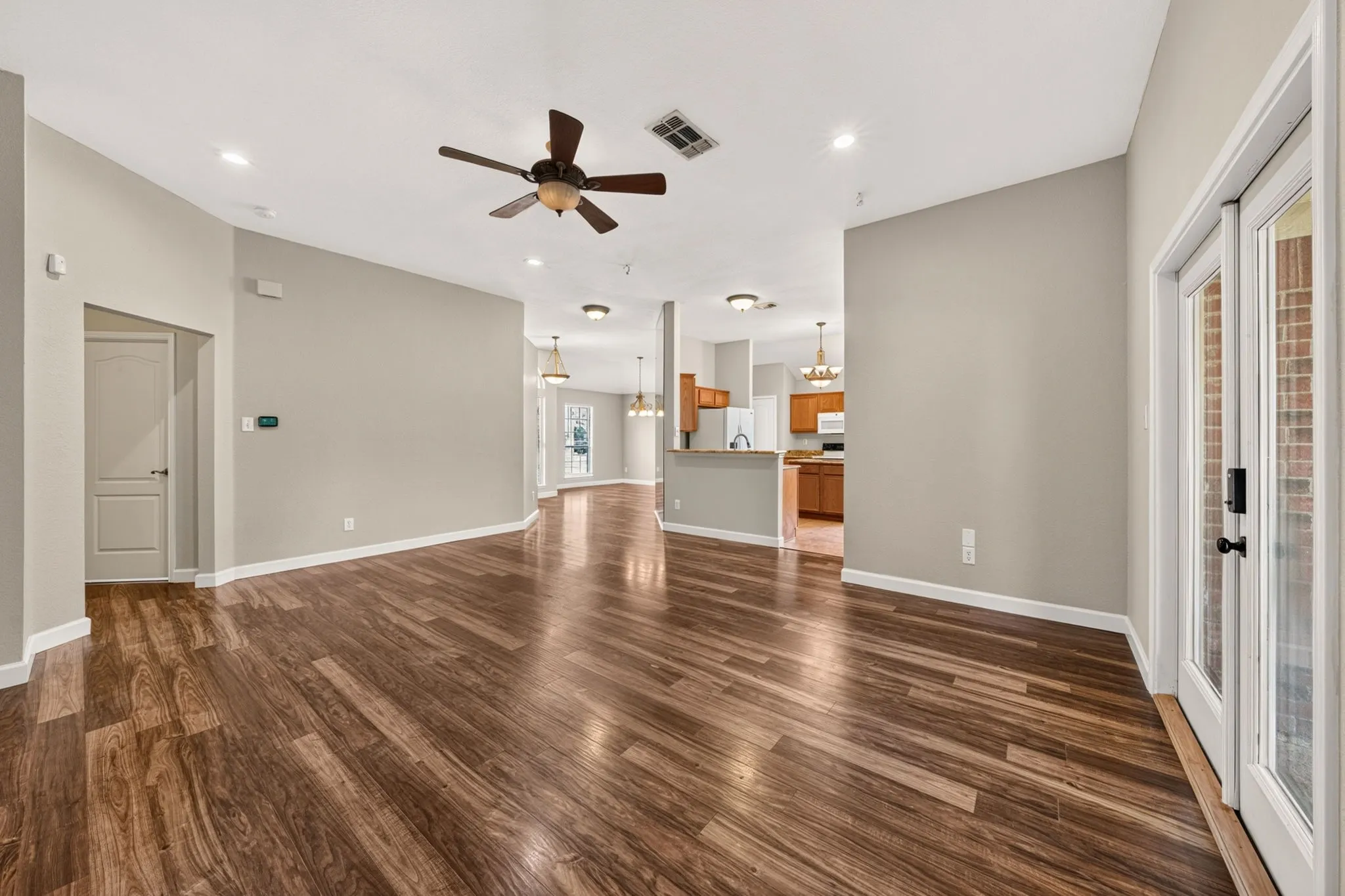 Spacious open concept interior featuring wood-finish flooring, fresh paint and recessed lighting