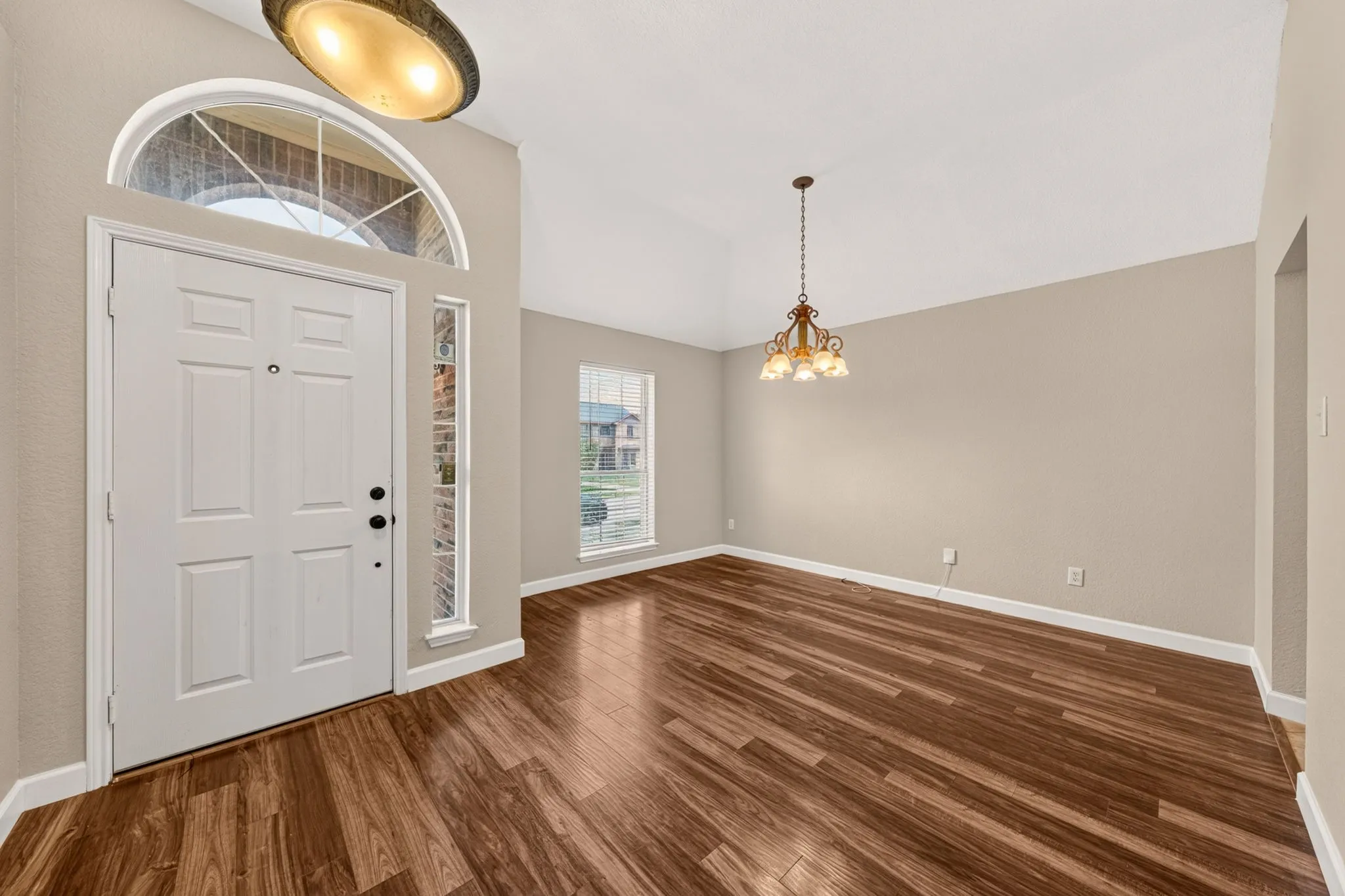 Entryway featuring a white panel door with an arched transom window
