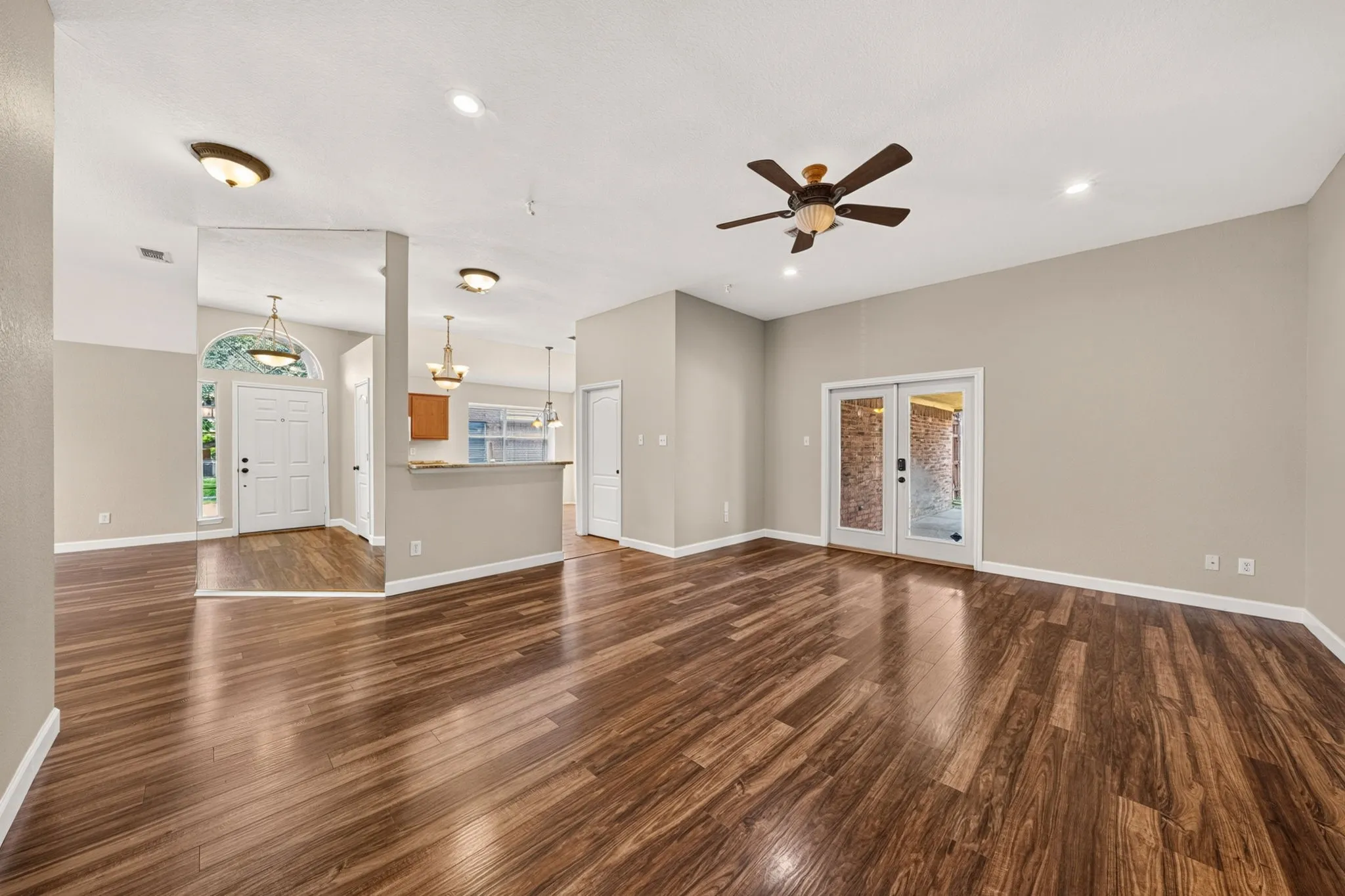Spacious living area featuring wood-finish flooring, recessed lighting, and a ceiling fan