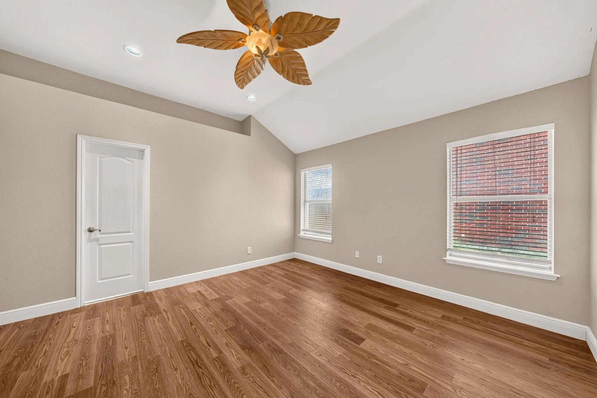 Vaulted ceiling room featuring wood-finish flooring, recessed lighting, and a decorative ceiling fan