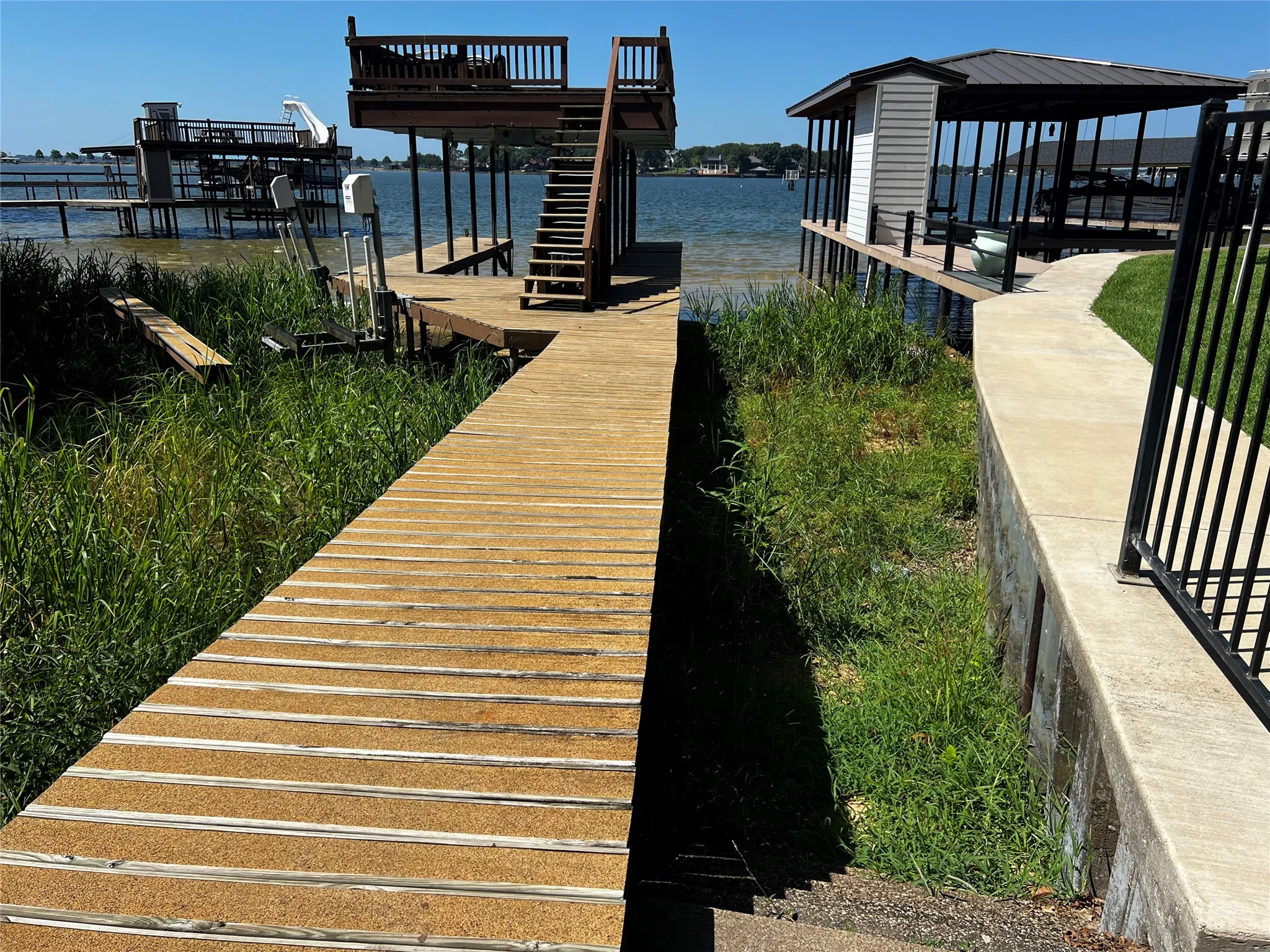 Pier to the dock and the lake entry stairs to the right between pier and retaining wall