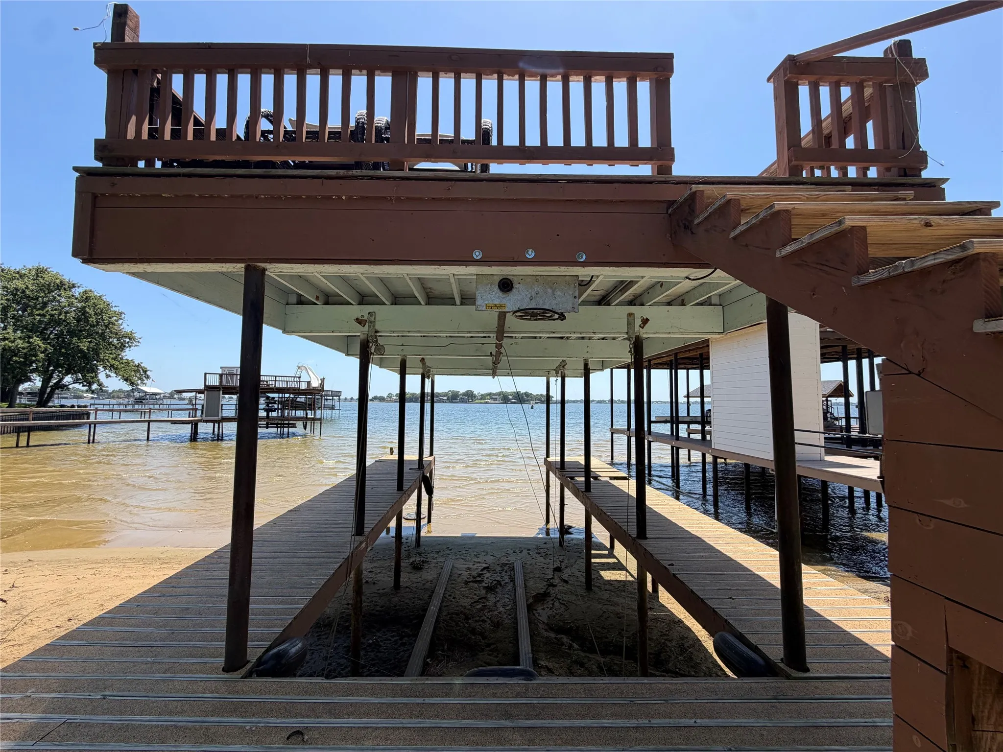 Waterfront dock featuring a boat slip, upper deck, and built-in stairs
