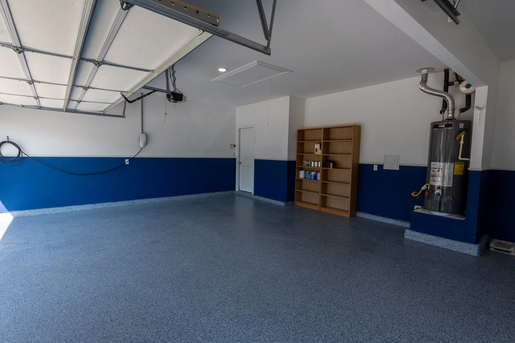Generous garage interior with epoxy flooring and excellent flexibility for parking, storage, or workspace.