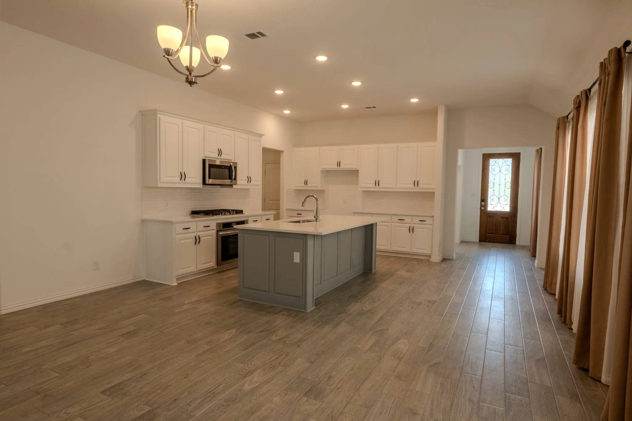 Open kitchen with a large center island and an easy connection to the surrounding living and entertaining spaces.