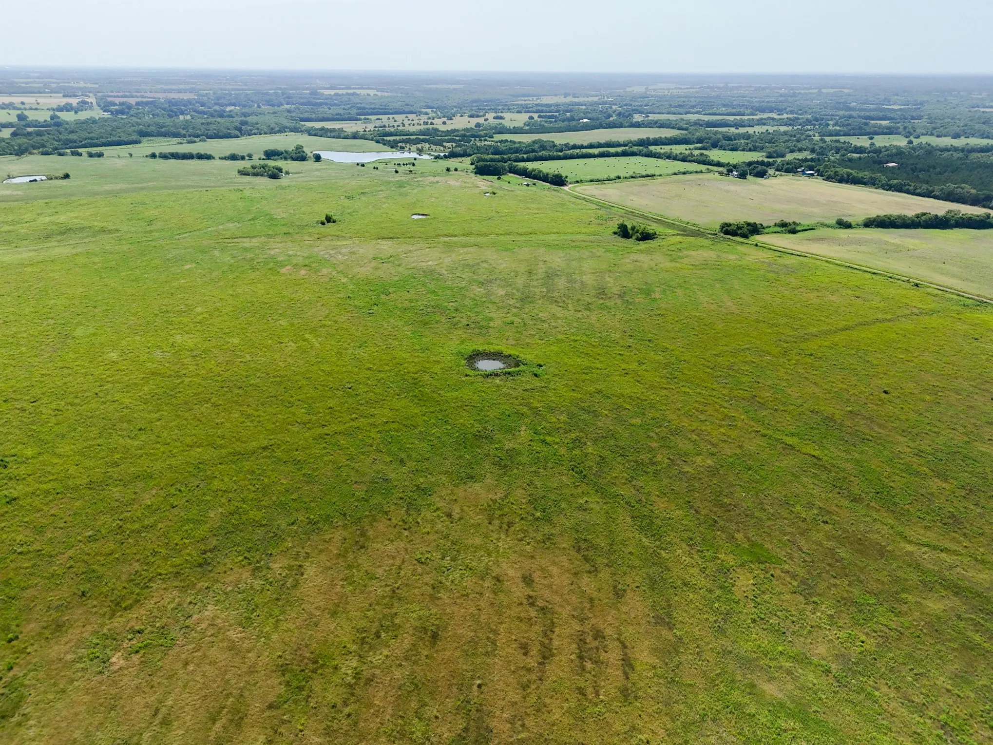 Expansive green acreage featuring multiple ponds and scattered tree lines