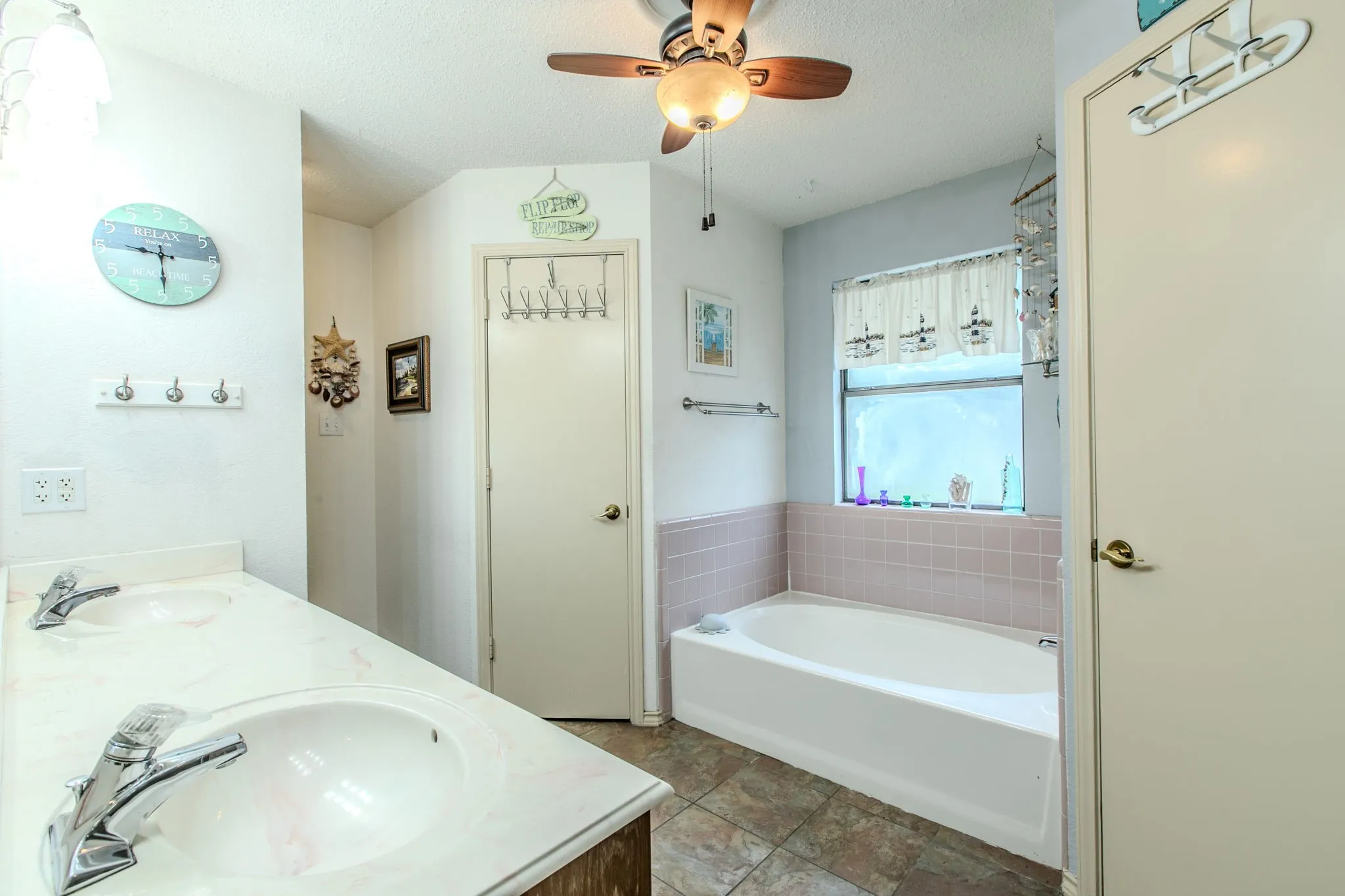 Bathroom featuring dual vanity with integrated sinks, chrome faucets, and a mounted mirror