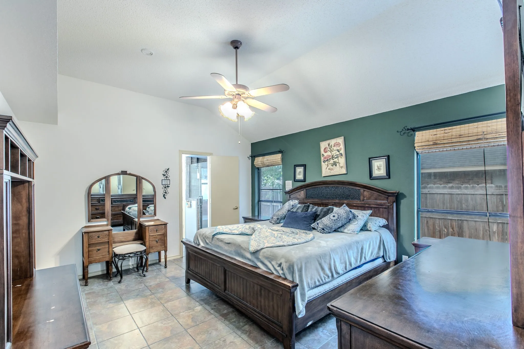 Spacious room featuring vaulted ceilings, a ceiling fan with integrated lighting, and tile flooring