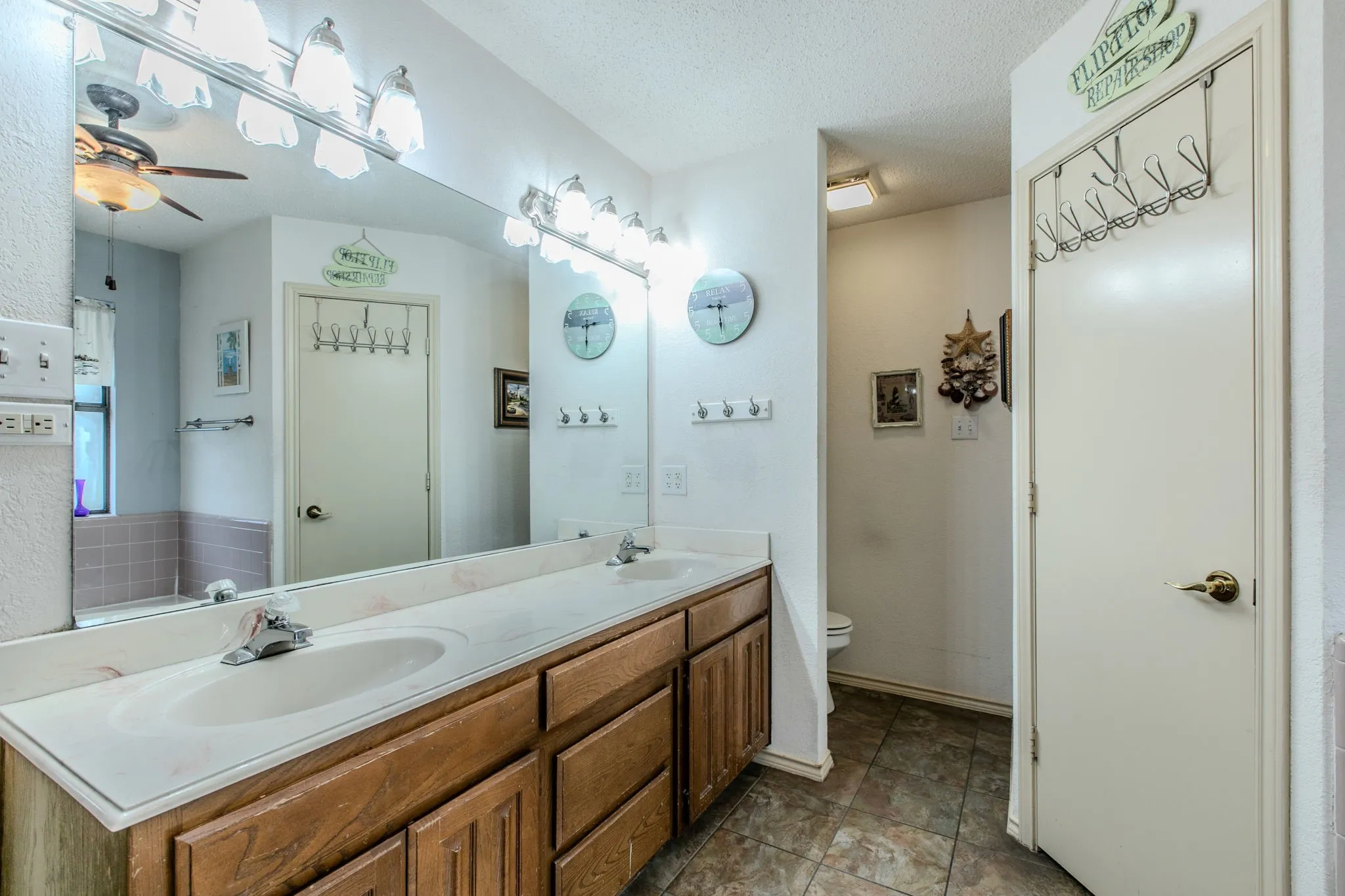 Double vanity with an integrated countertop and two sinks, set atop a wood-finish cabinet