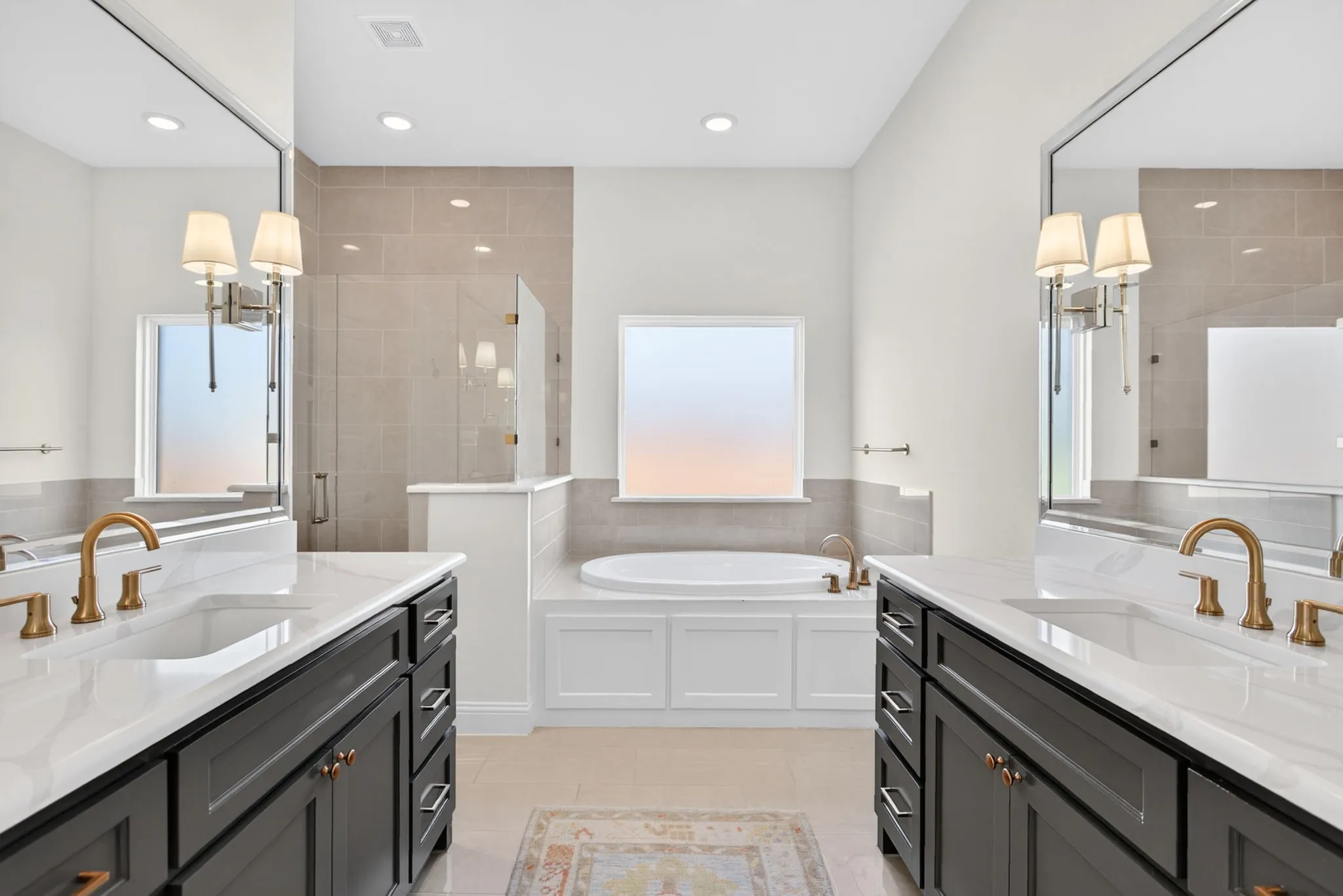 The primary ensuite feels like an upscale hotel.  Sconce accent lighting, LED ceiling lighting,  tile floors.