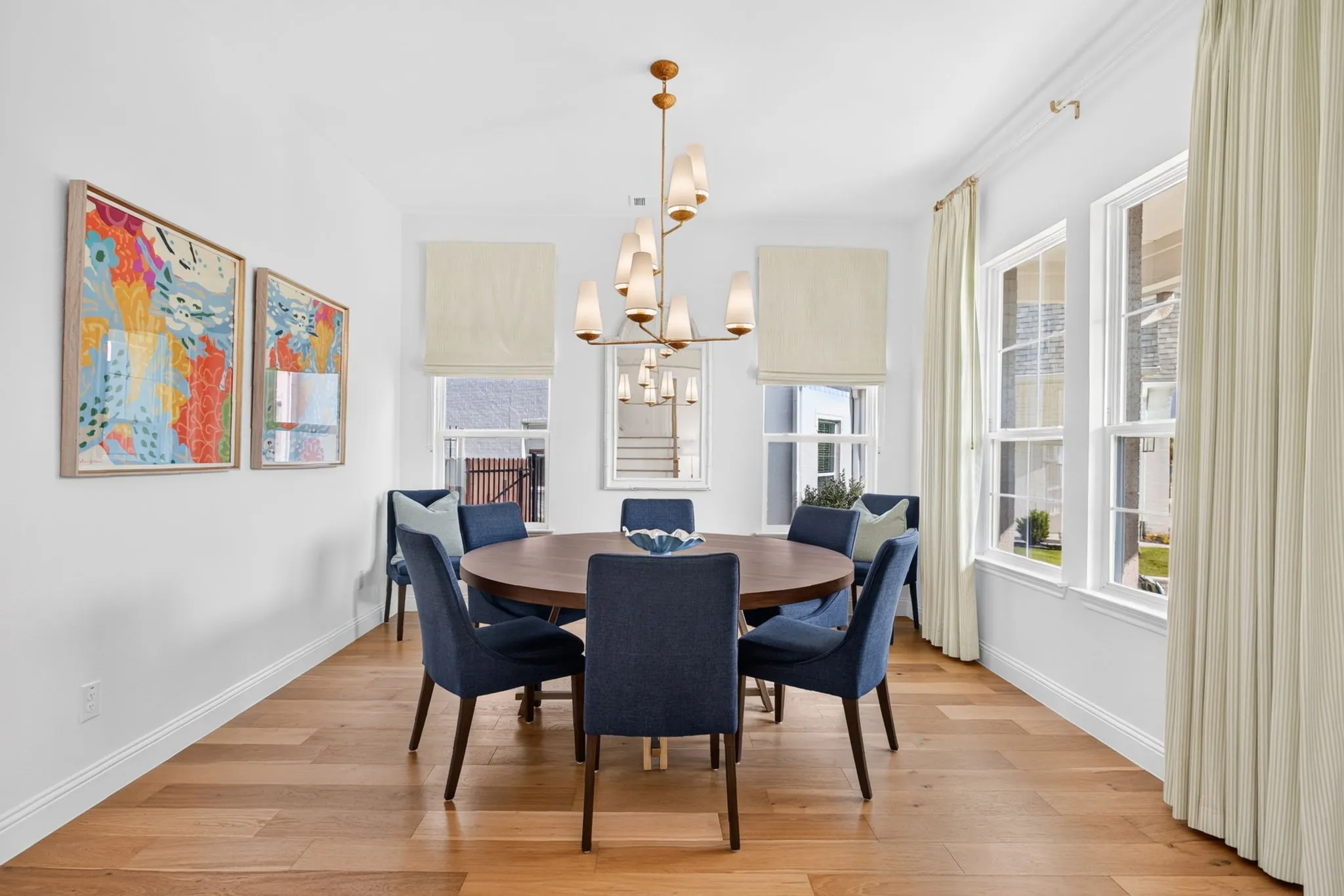 Formal dining off of the foyer with lighting from Visual Comfort & Co.  Windows surrounding the space.