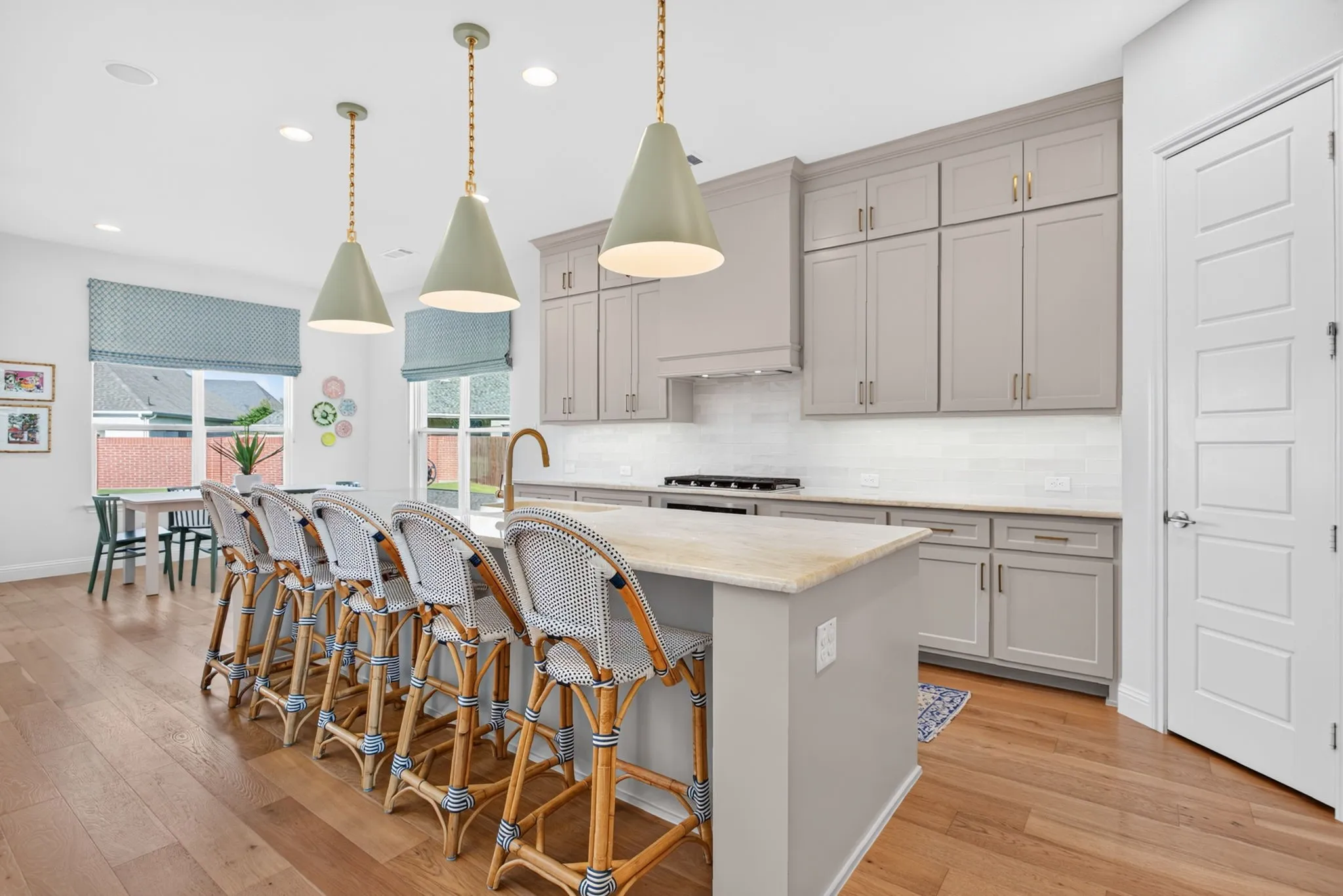 Visual Comfort & Co pendant lights, griege cabinets with champagne hardware.