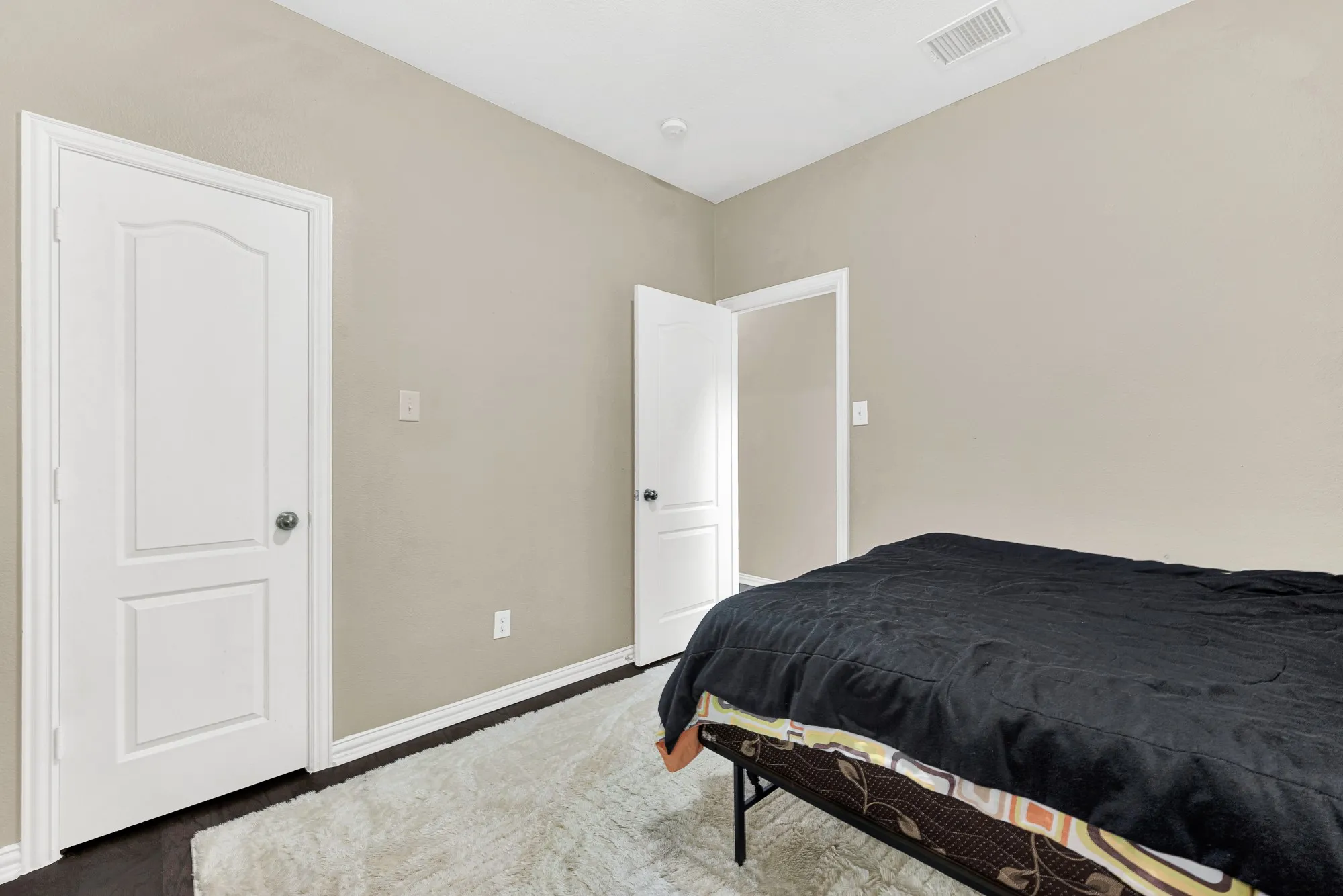 Neutral-toned walls, dark wood-finish flooring, and white trim