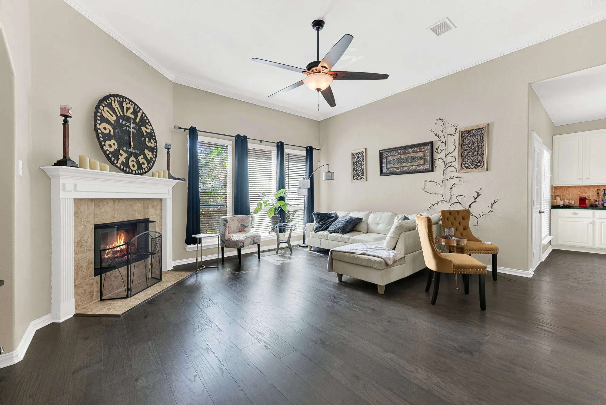 Wood-finish flooring throughout, a fireplace with a stone surround, and an archway