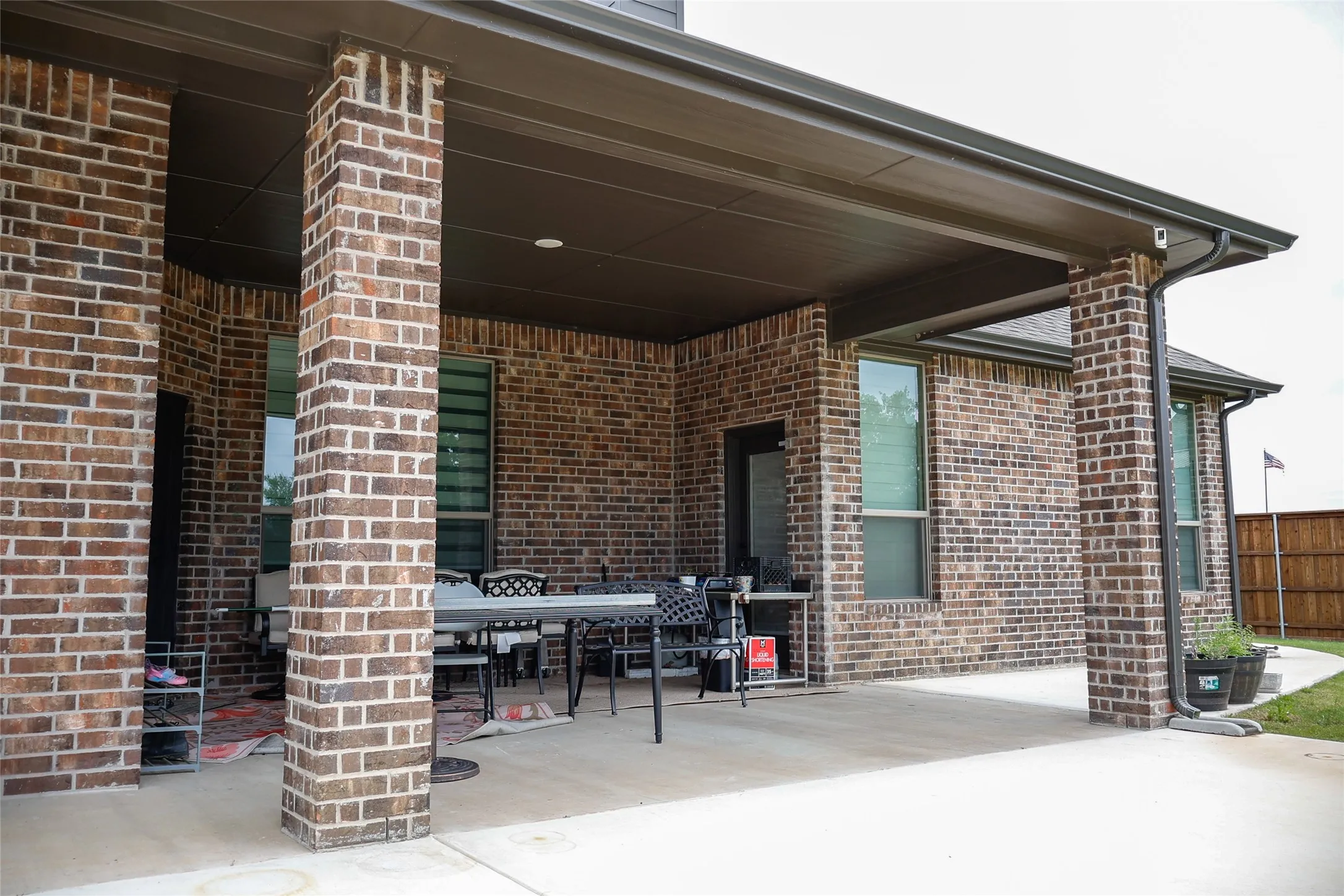 Covered patio featuring brick columns, recessed lighting, concrete flooring, and a seamless gutter system
