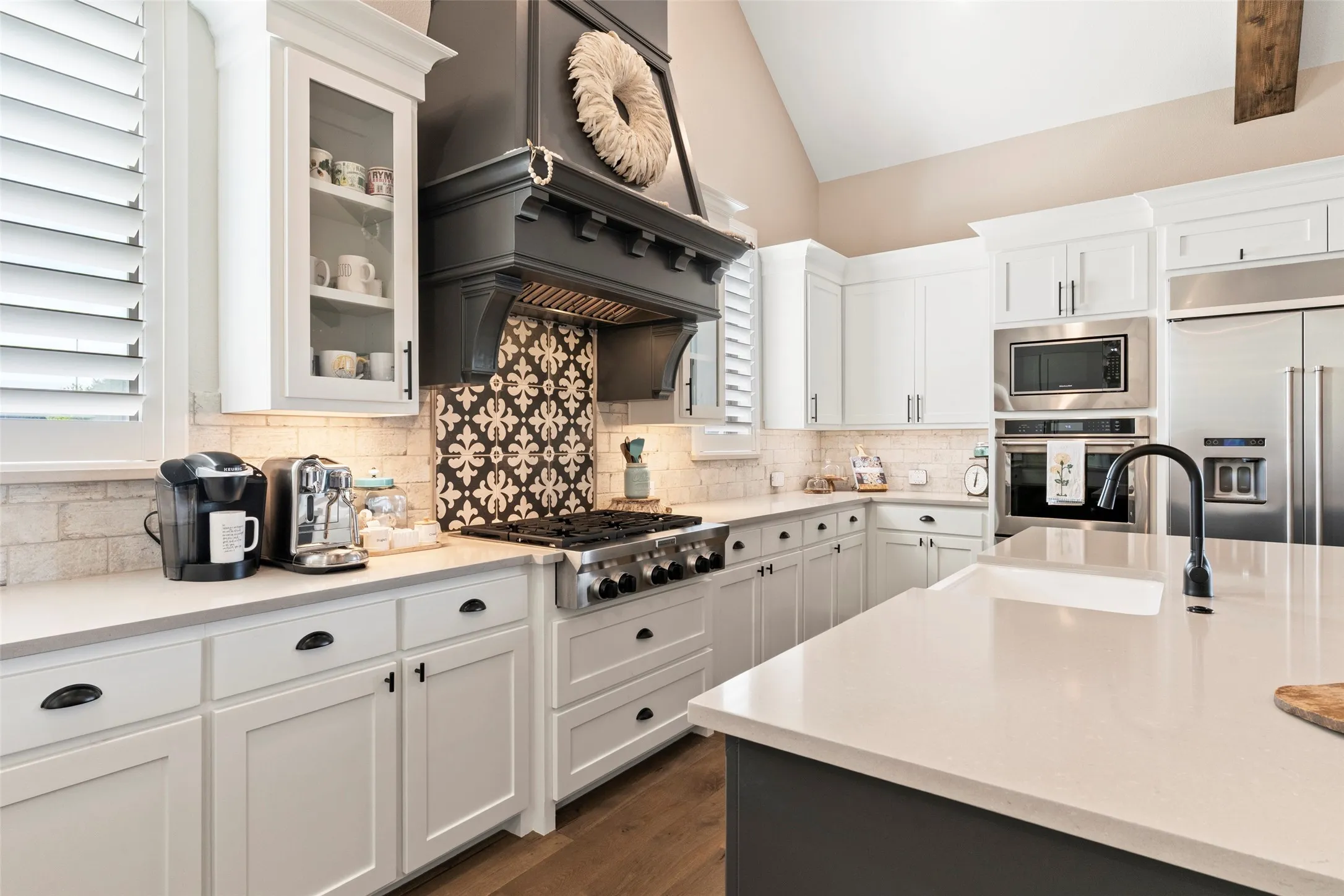 Designer selections accent the focal point of the kitchen.  Custom shutters throughout the home and garage.
