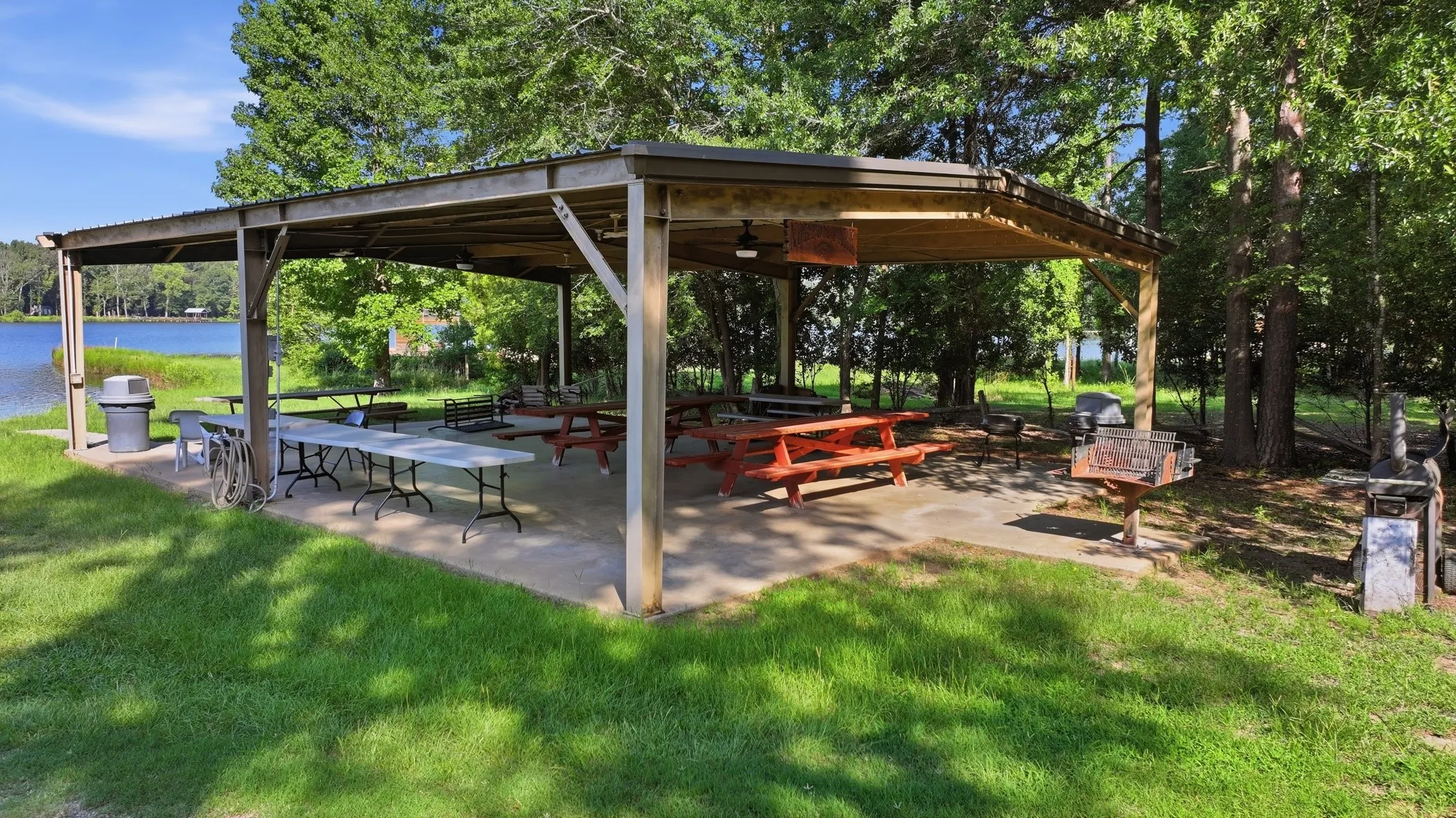 Waterfront covered pavilion with concrete flooring, wood structural beams, and a metal roof