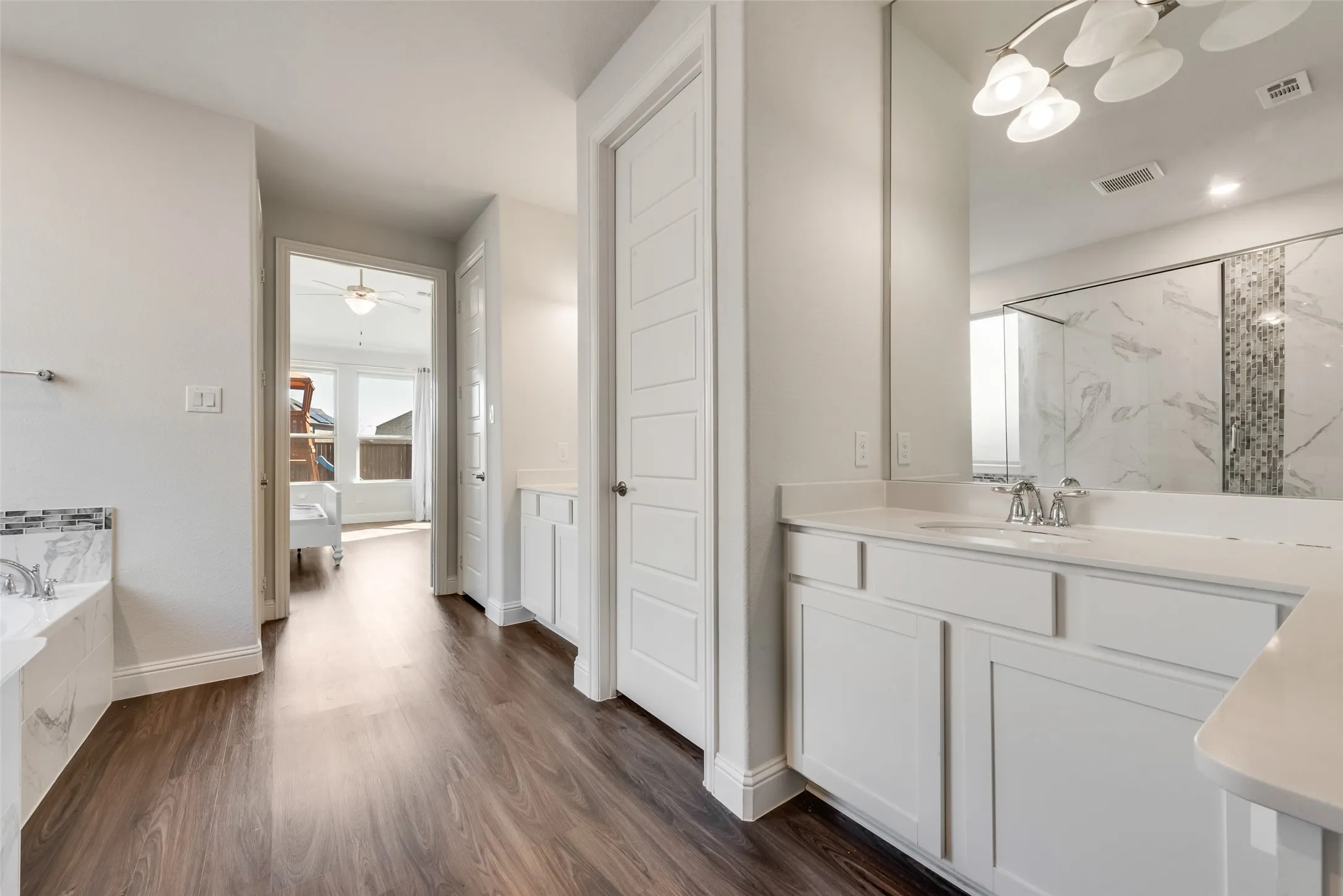 Bathroom vanity with white cabinetry, a light-toned countertop, and an overhead light fixture