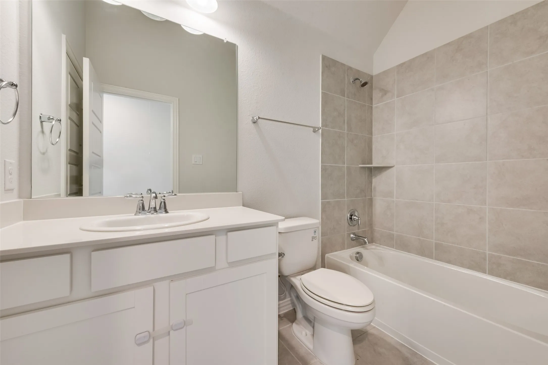 Bathroom featuring a vanity with white cabinetry, a built-in sink, and a large mirror