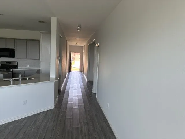 Open concept layout featuring wood-finish flooring, recessed lighting, and a kitchen with gray cabinetry, a tile backsplash, and a breakfast bar