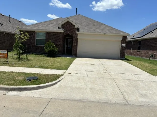 Brick facade home featuring an attached garage and a concrete driveway