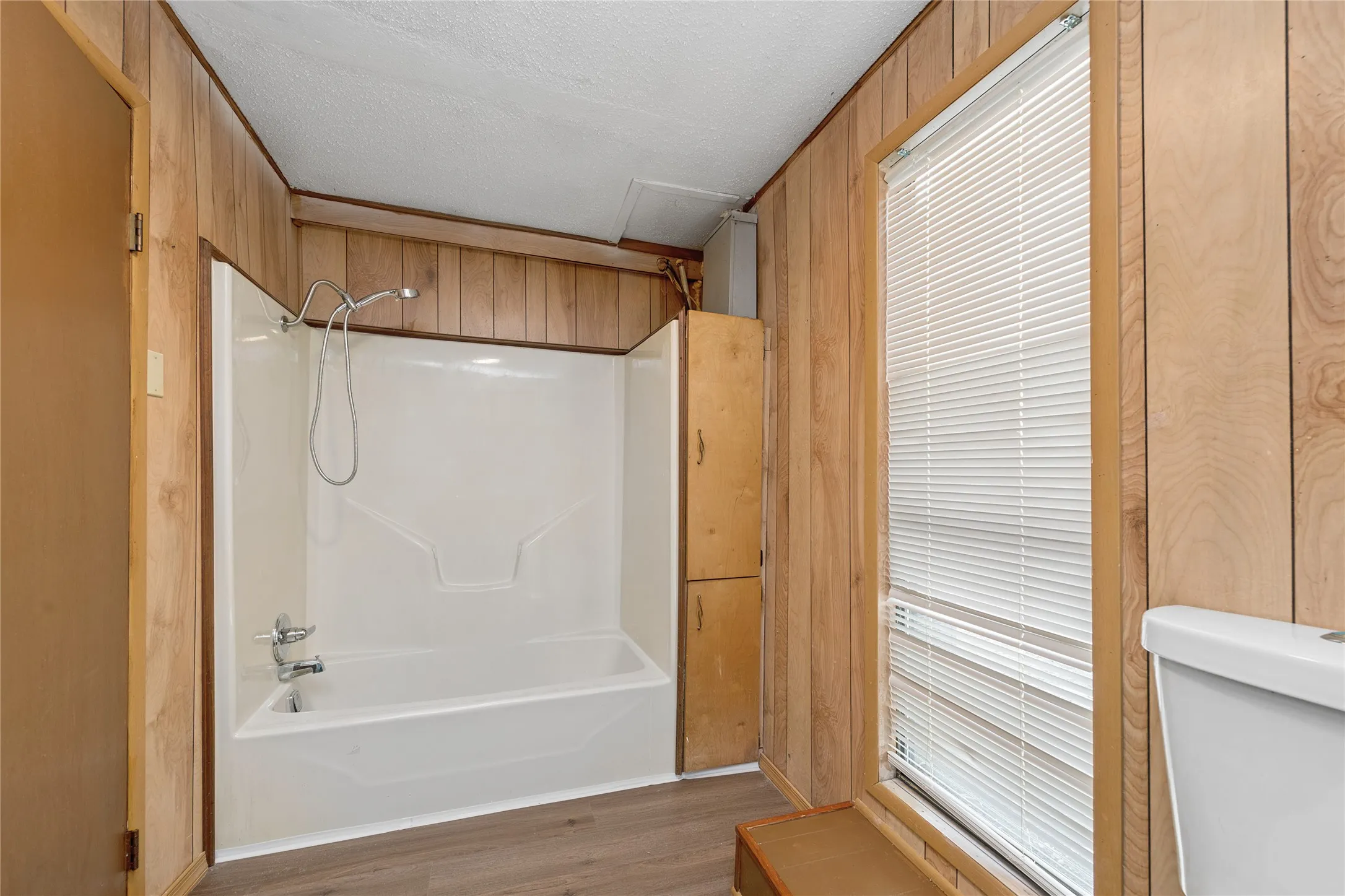 White tub/shower combination with a chrome shower head and faucet