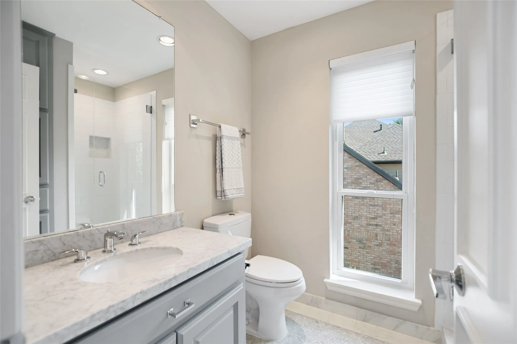 Bathroom featuring a gray vanity with a stone countertop, an undermount sink, and a chrome faucet