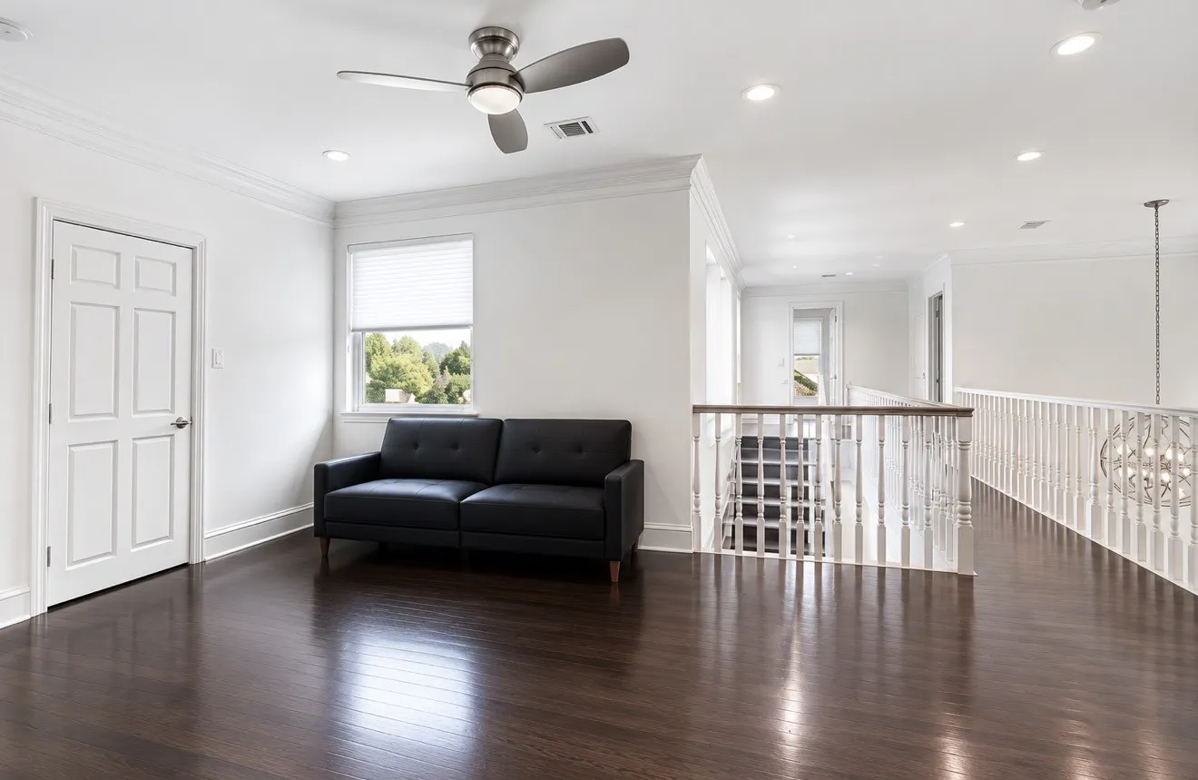 Open loft space featuring dark wood-finish flooring, white walls, and recessed lighting