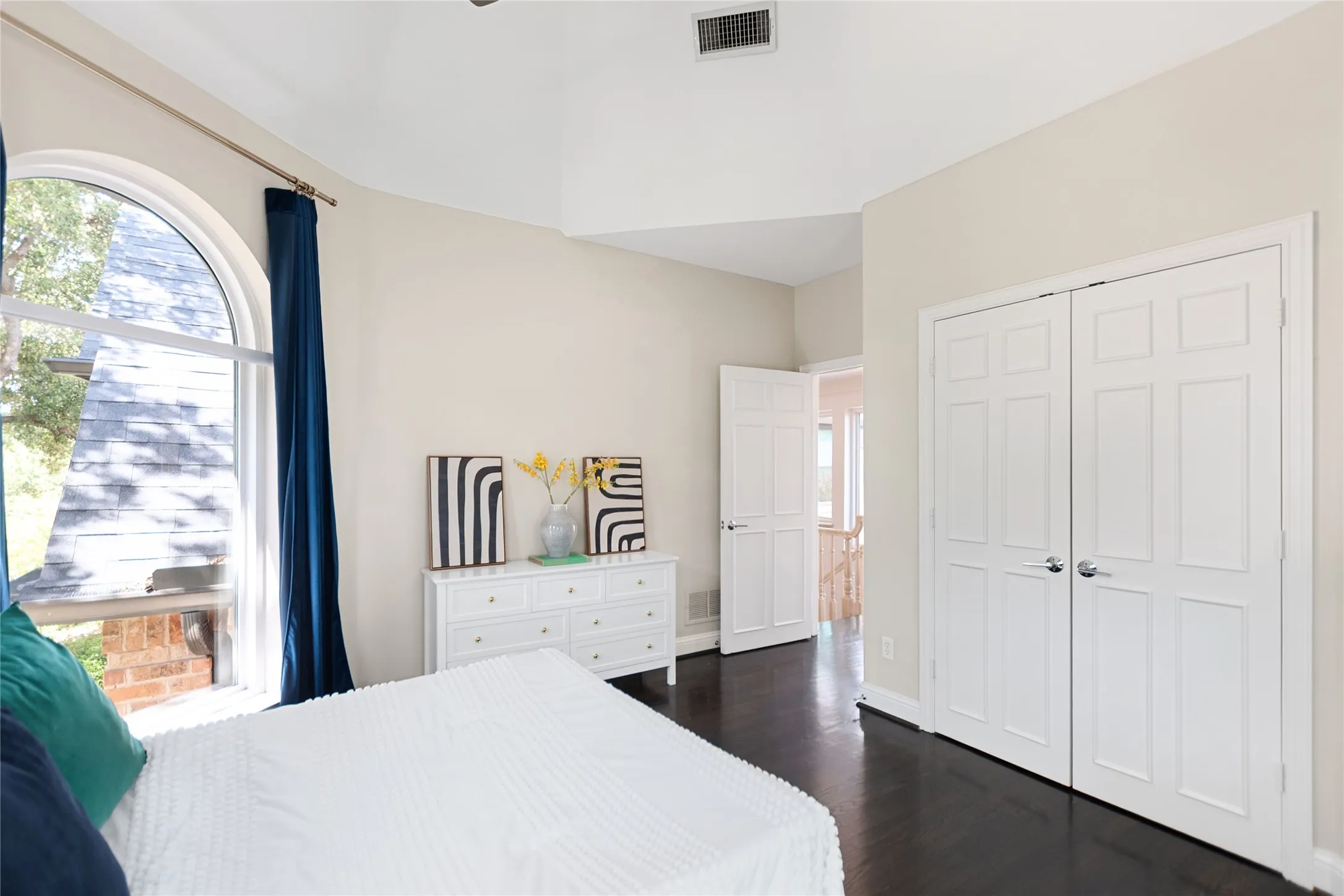 Room featuring a vaulted ceiling and dark wood-finish flooring