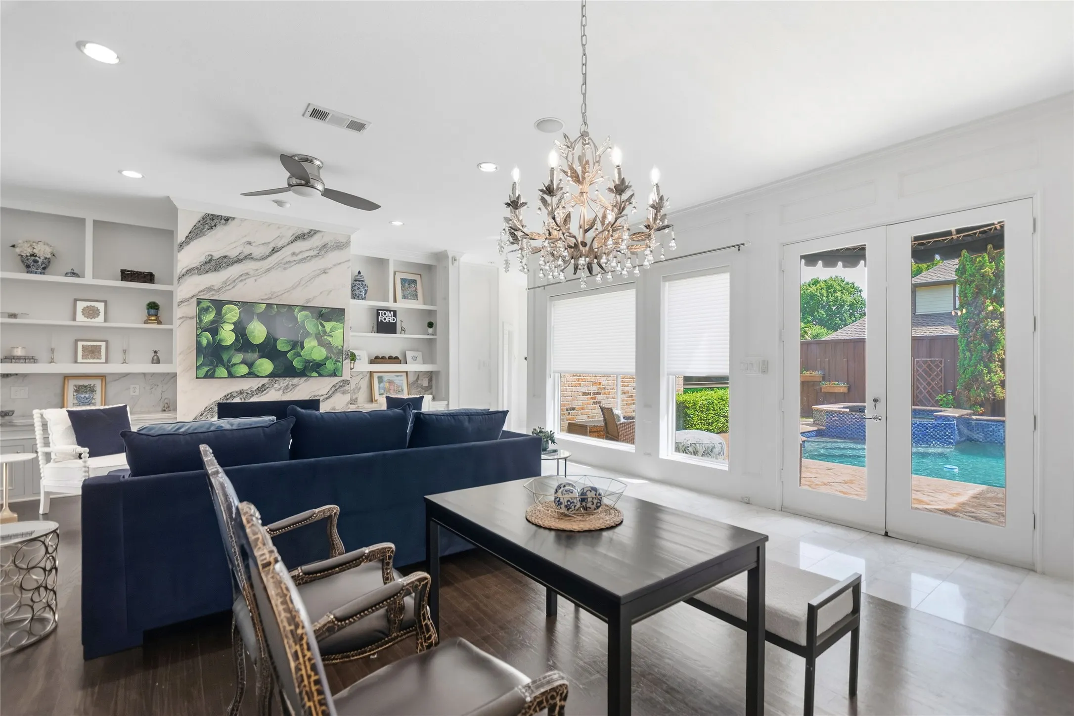 Living area with a marble-clad fireplace, integrated shelving, and recessed lighting